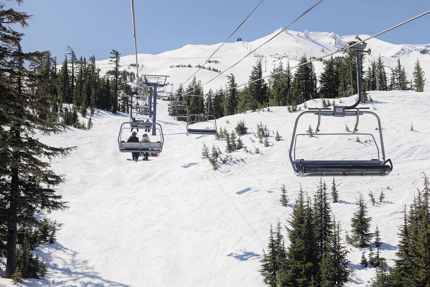 A snowy mountain landscape with ski lifts transporting skiers up the slopes.