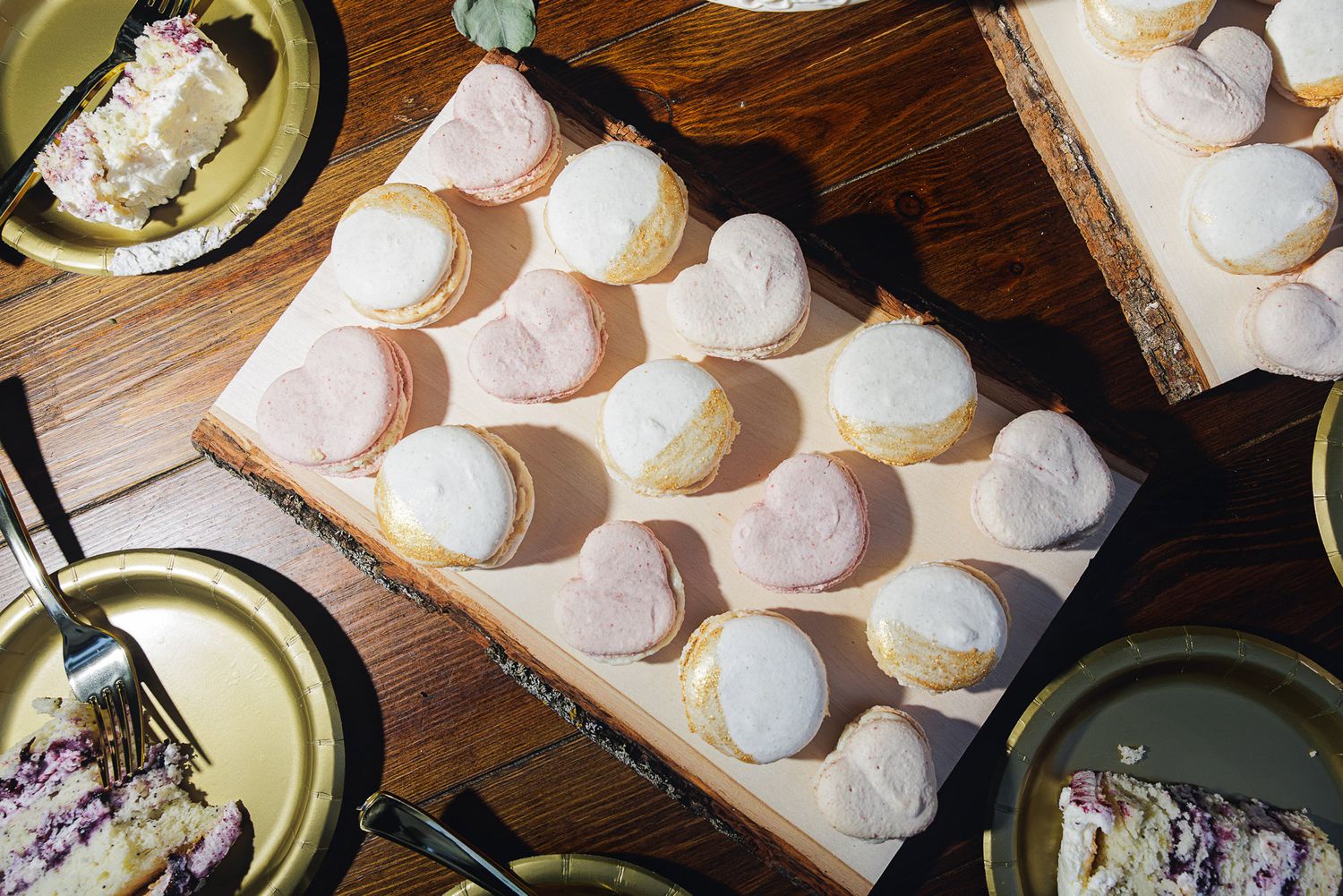 Homemade meringue cookies arranged in rows on parchment paper with a piping bag visible in the background.