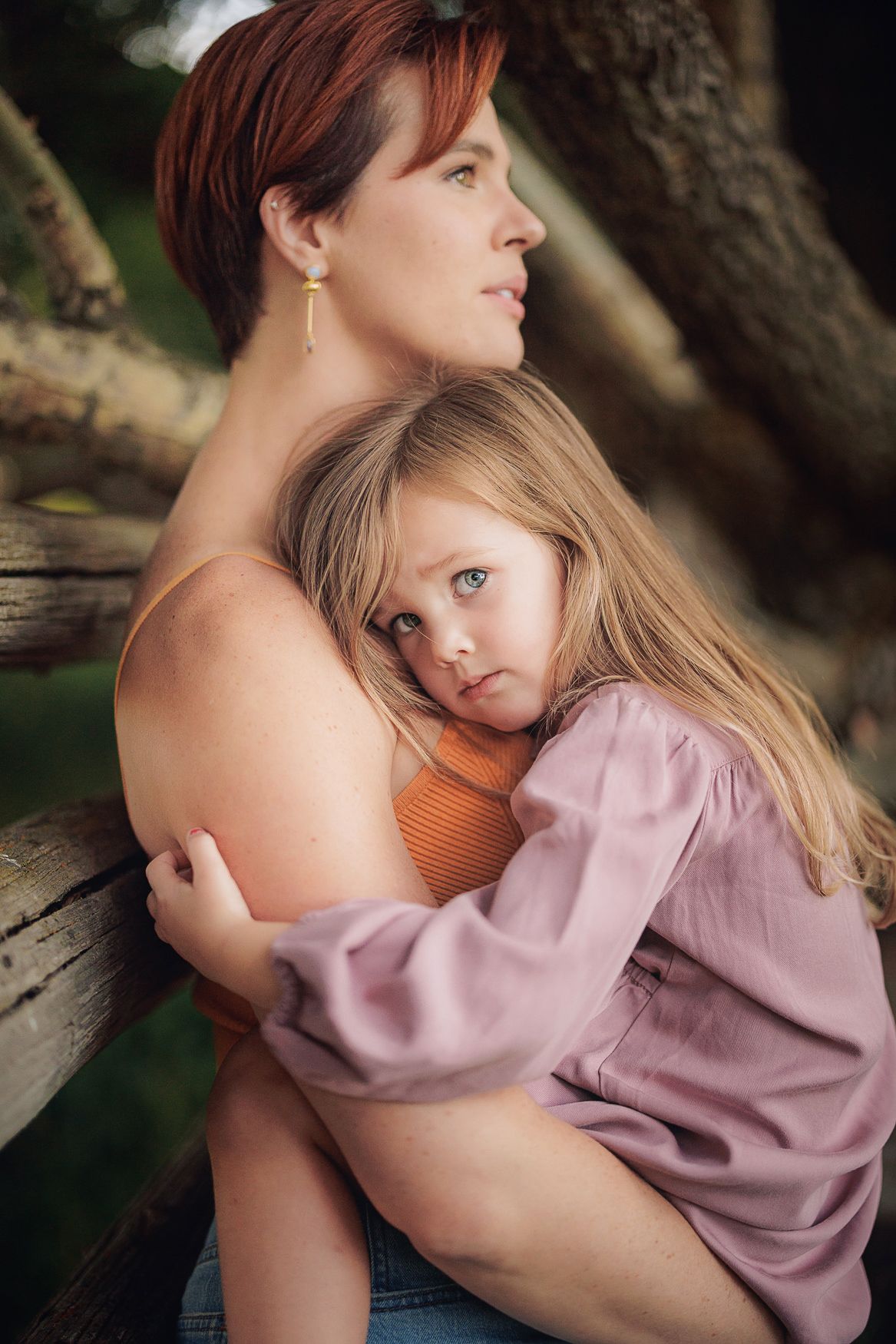 Intimate portrait of parent and child embracing in natural outdoor setting.