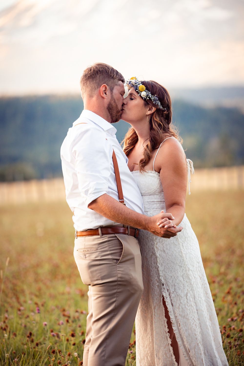 A couple shares an intimate moment in a rustic outdoor setting at sunset.