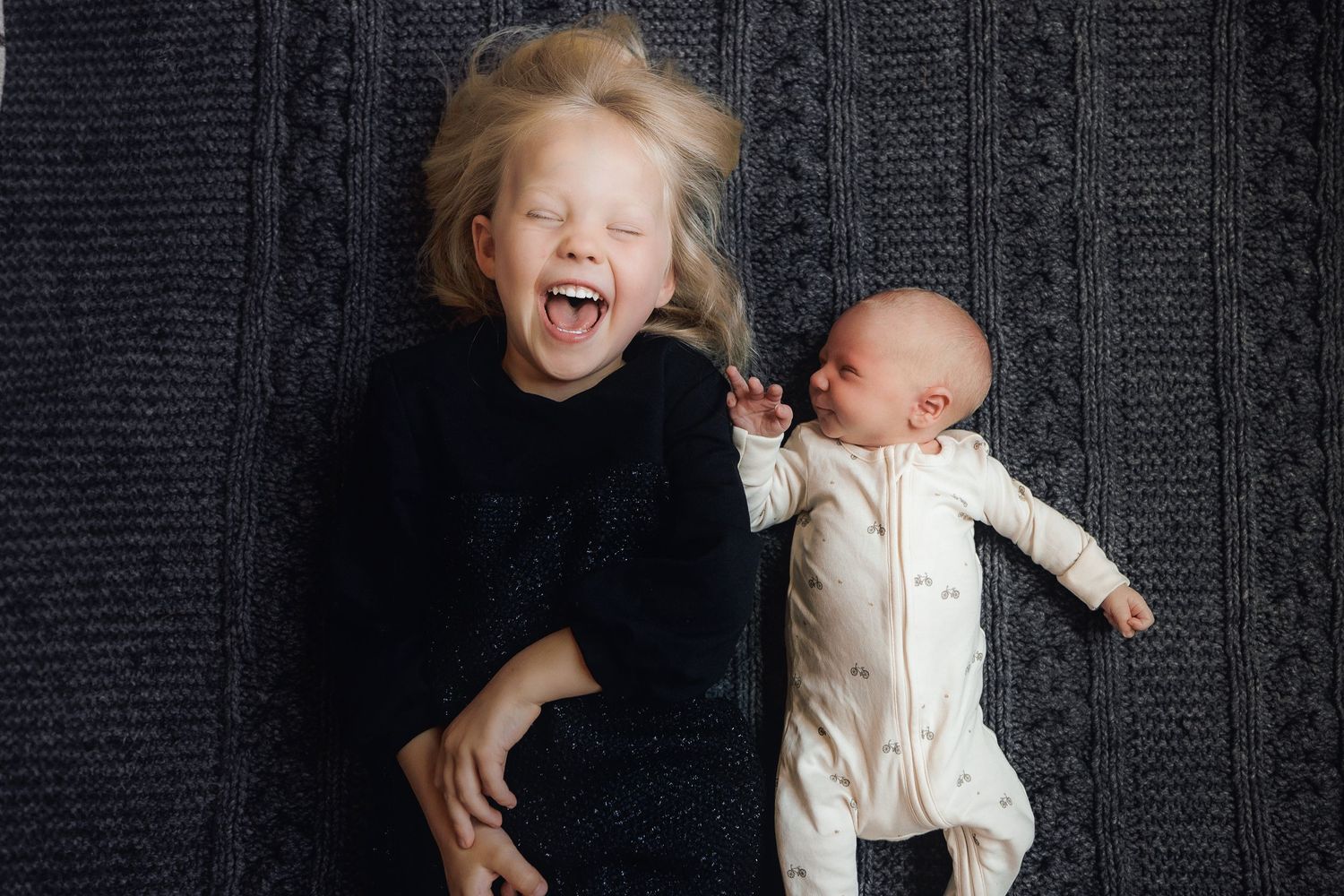 A joyful moment captured on a dark background with children sharing laughter together.