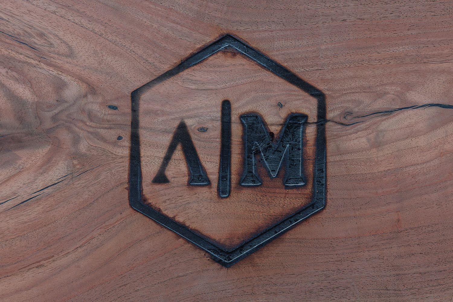 Close-up shots of wooden signs with carved designs and text mounted on a wooden wall.
