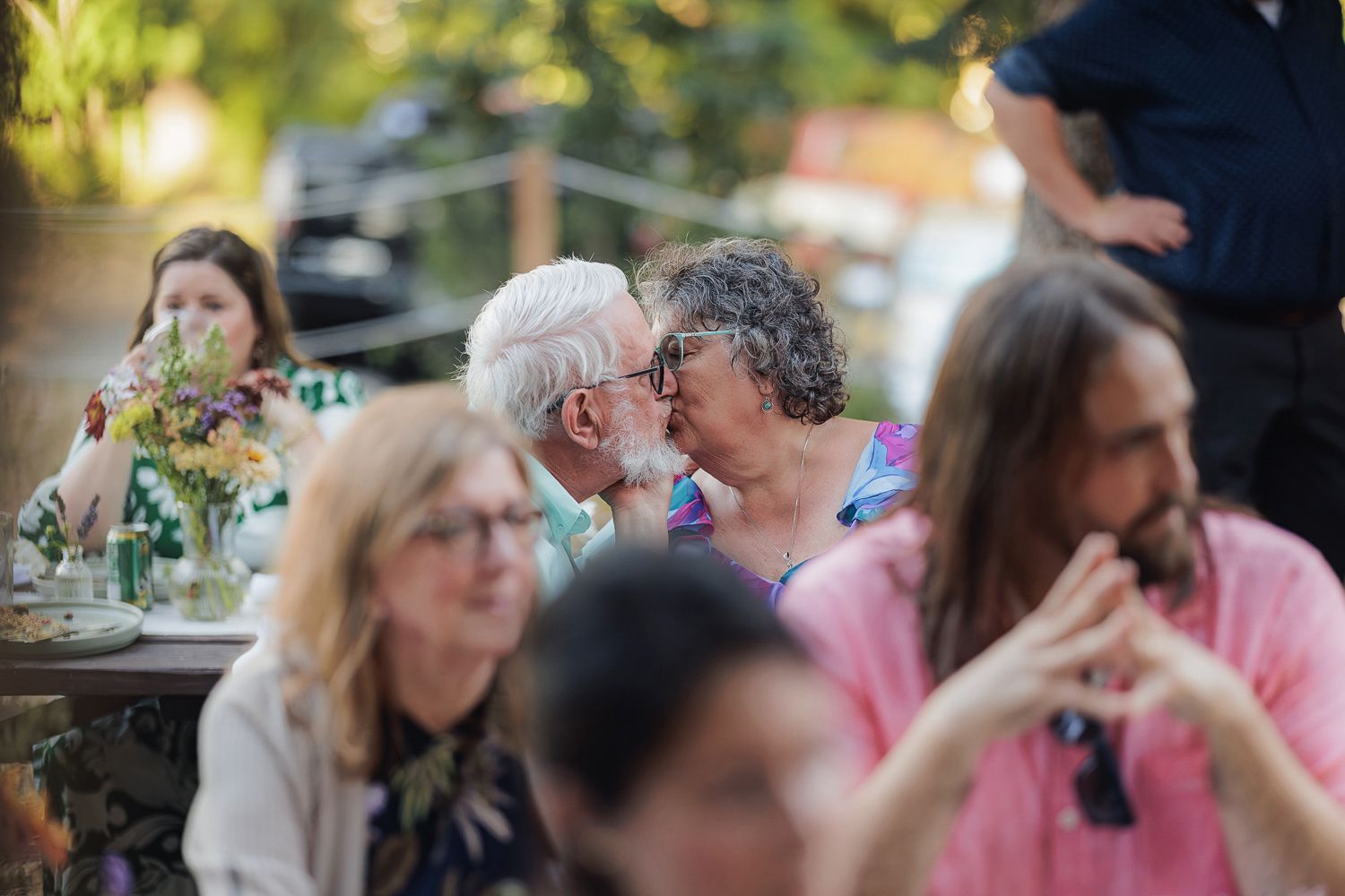 People enjoy an outdoor dining experience at a restaurant patio filled with casual conversation and summer ambiance.