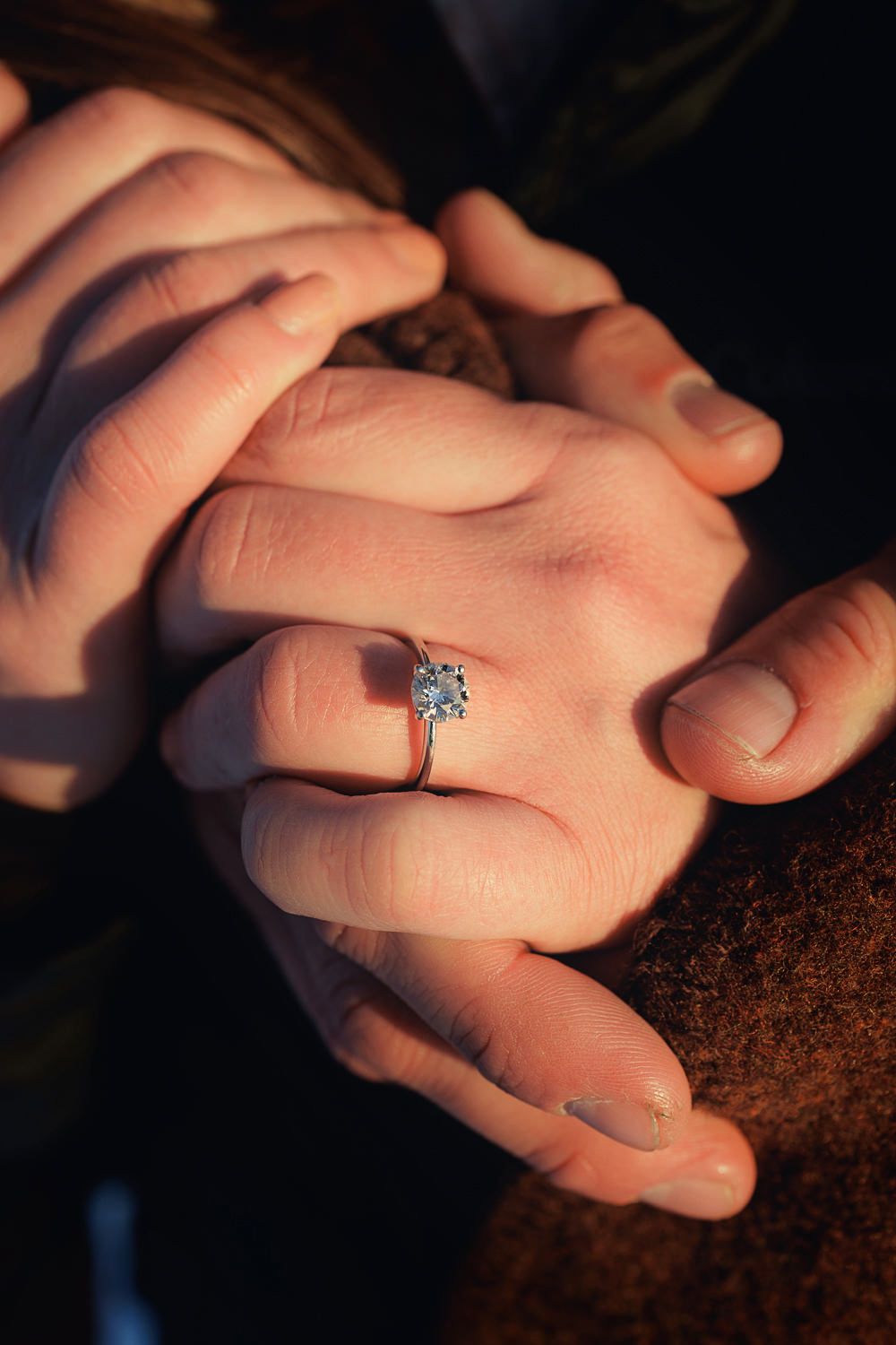 Closeup sequence of hands showing engagement ring on dark textured background in romantic proposal moment.
