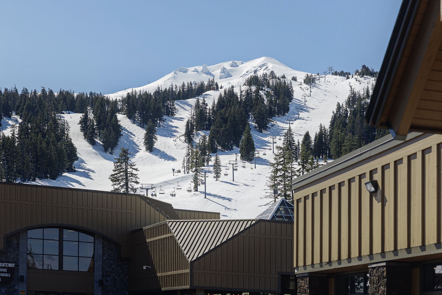 A snowy mountain landscape with ski slopes and ski lifts visible in the background.