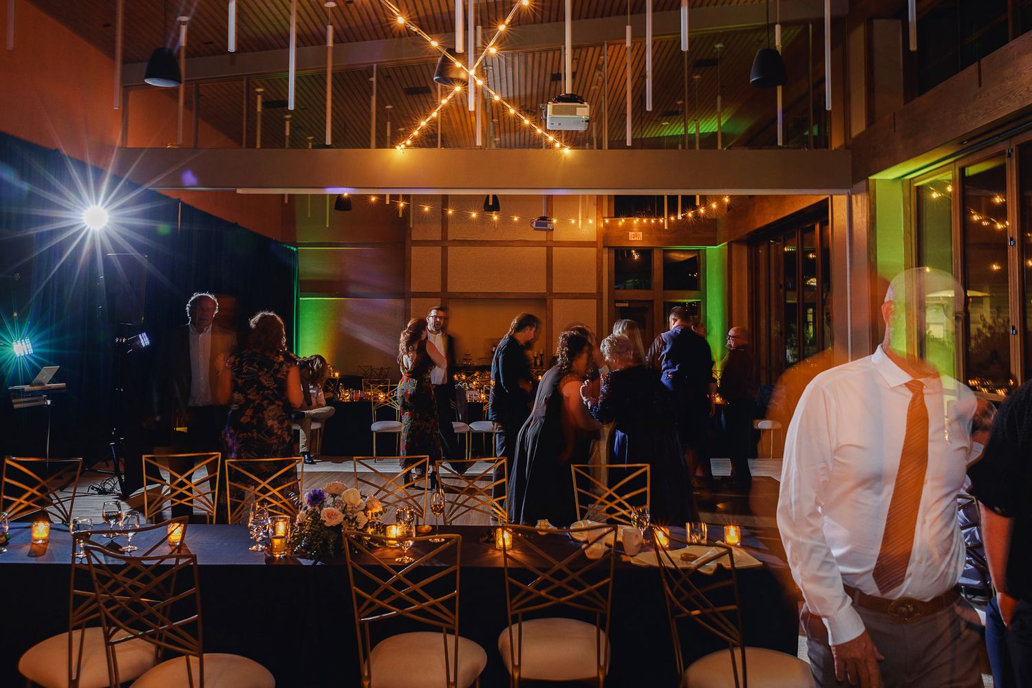 Wedding reception venue decorated with warm string lights and elegant table settings for an evening celebration.