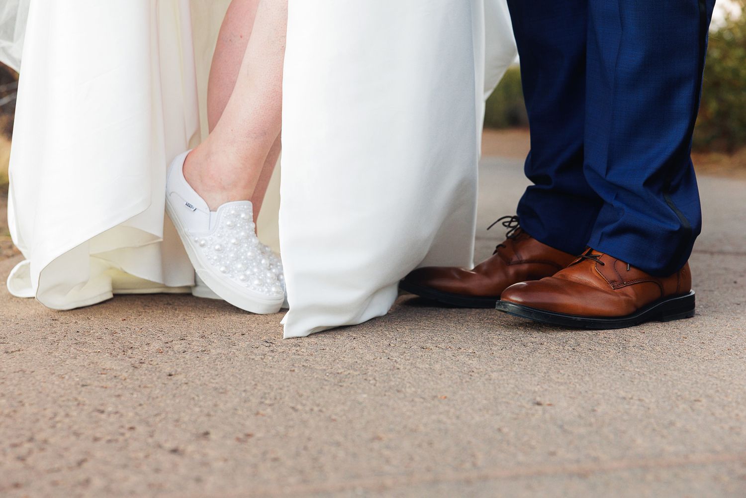 Close-up view of formal dress shoes and wedding gowns at the bottom of a group photo.