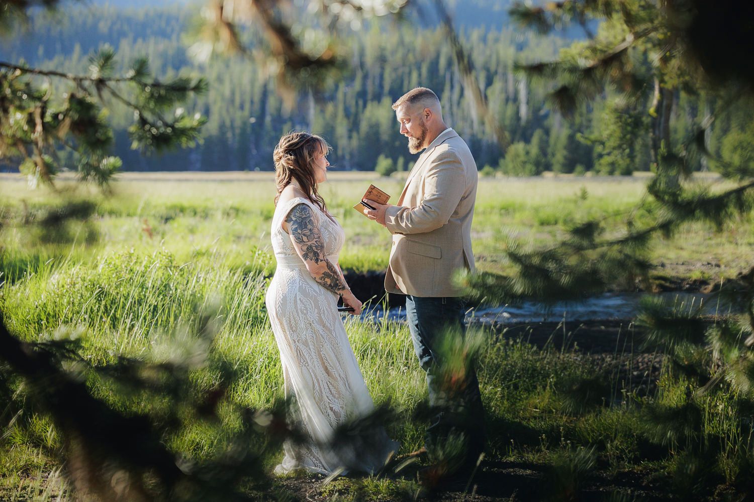 A couple shares an intimate moment in a sunlit meadow during a romantic outdoor wedding ceremony.