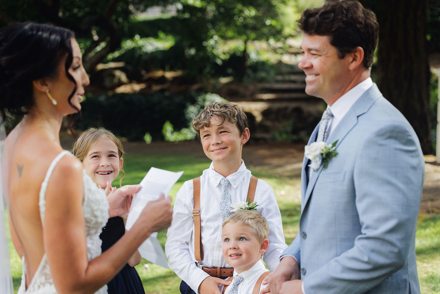 A joyful wedding celebration in an outdoor garden setting with guests mingling and laughing together.