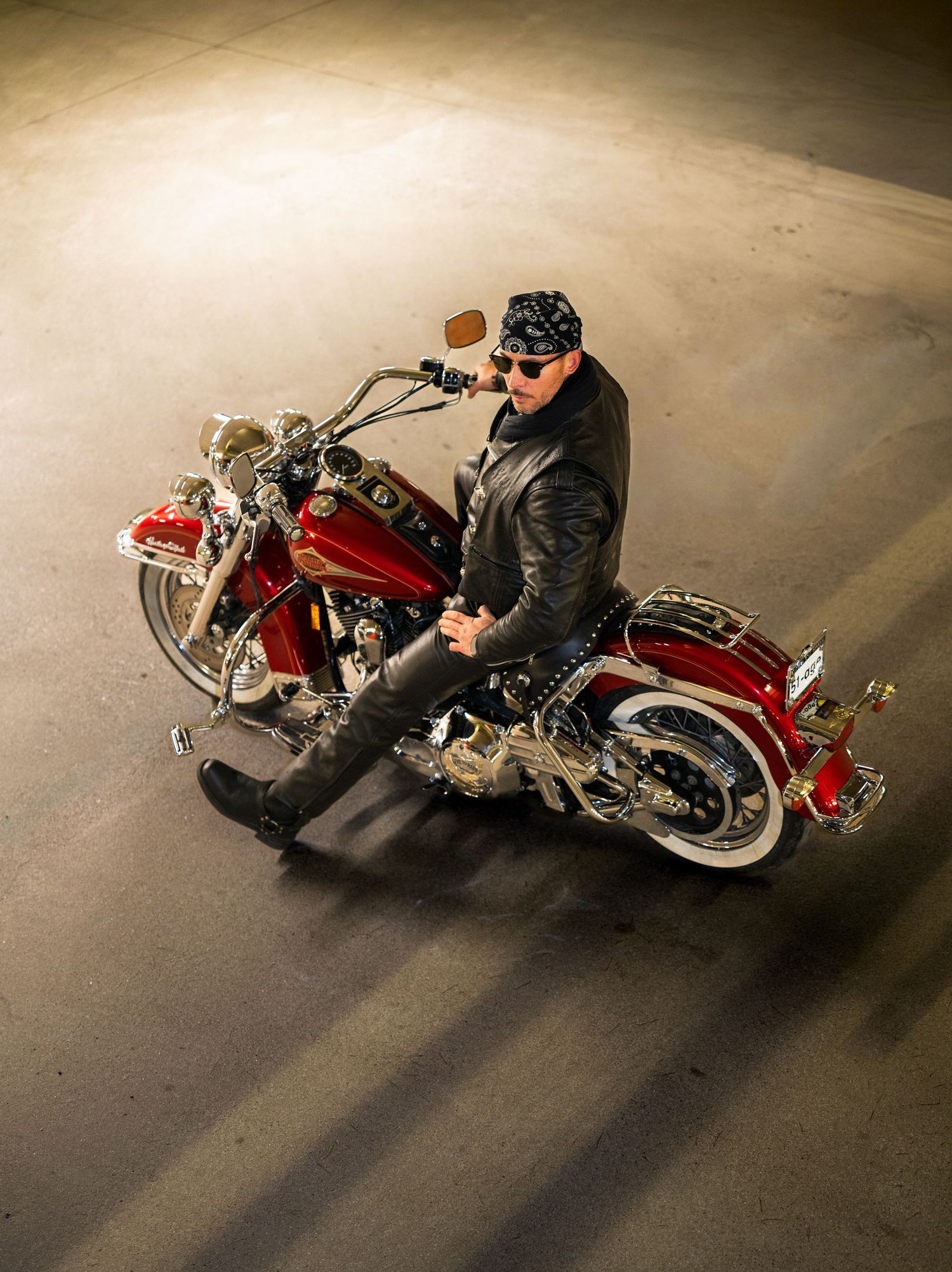 A sequence of five photos showing a custom red motorcycle from different angles on a dark concrete floor.