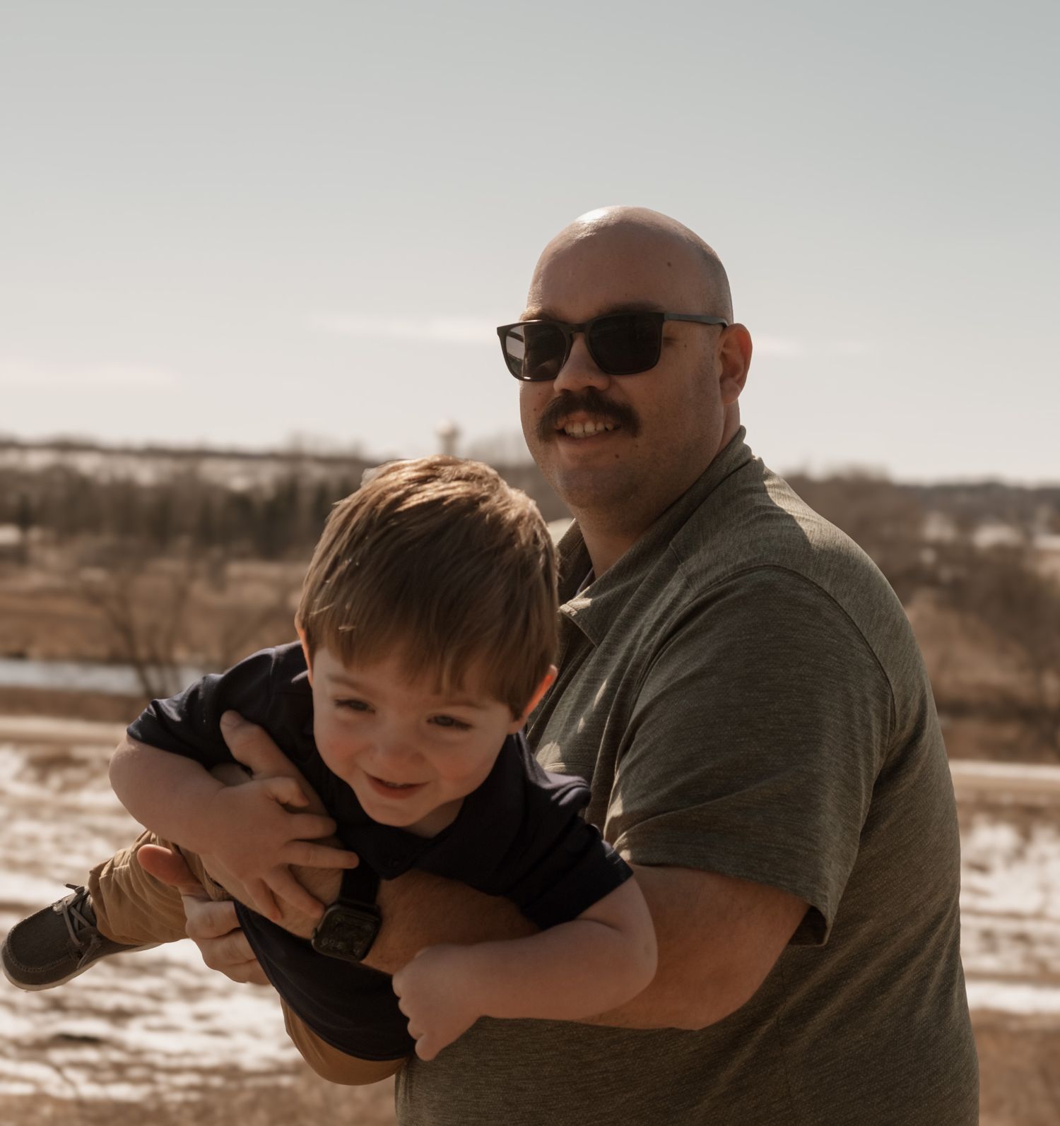 A heartwarming moment shared between parent and child playing outdoors in warm sunlight.