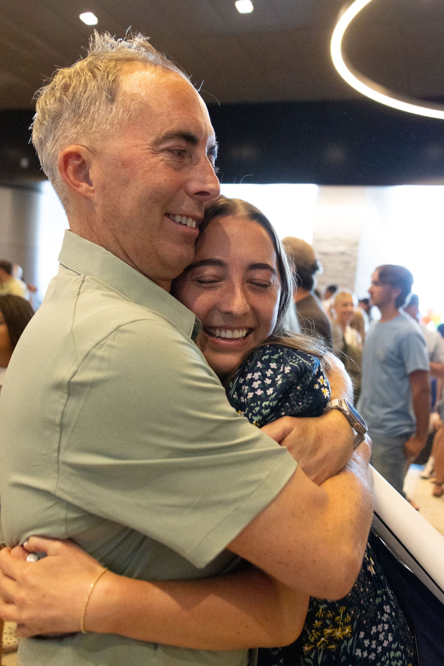 Dad and return missionary daughter share a joyful embrace at an airport reunion at the Salt Lake airport.