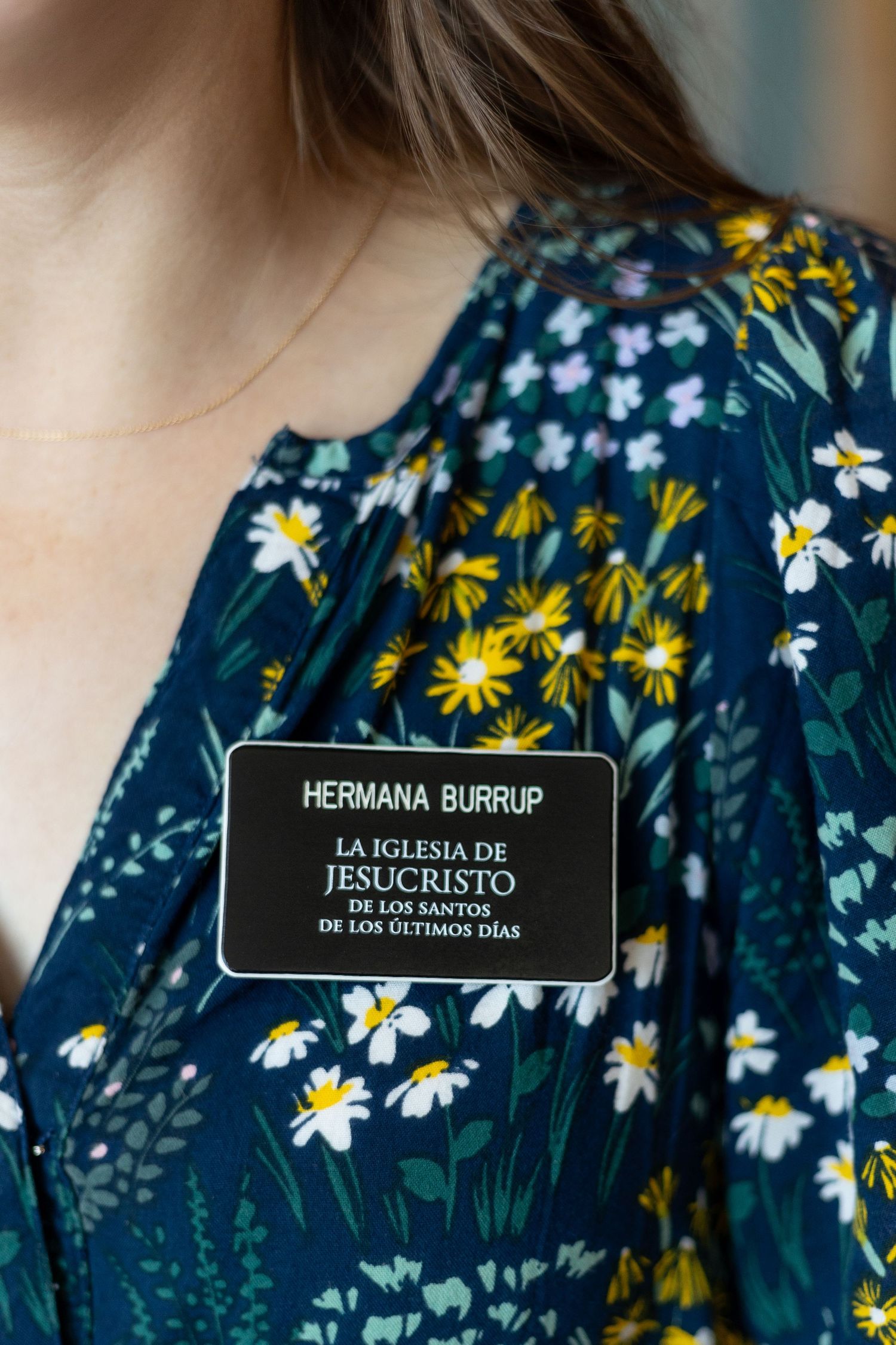 Close-up of a missionary name tag reading Hermana Burrup, La Iglesia de Jesucristo de los Santos de los Ultimos Dias.
