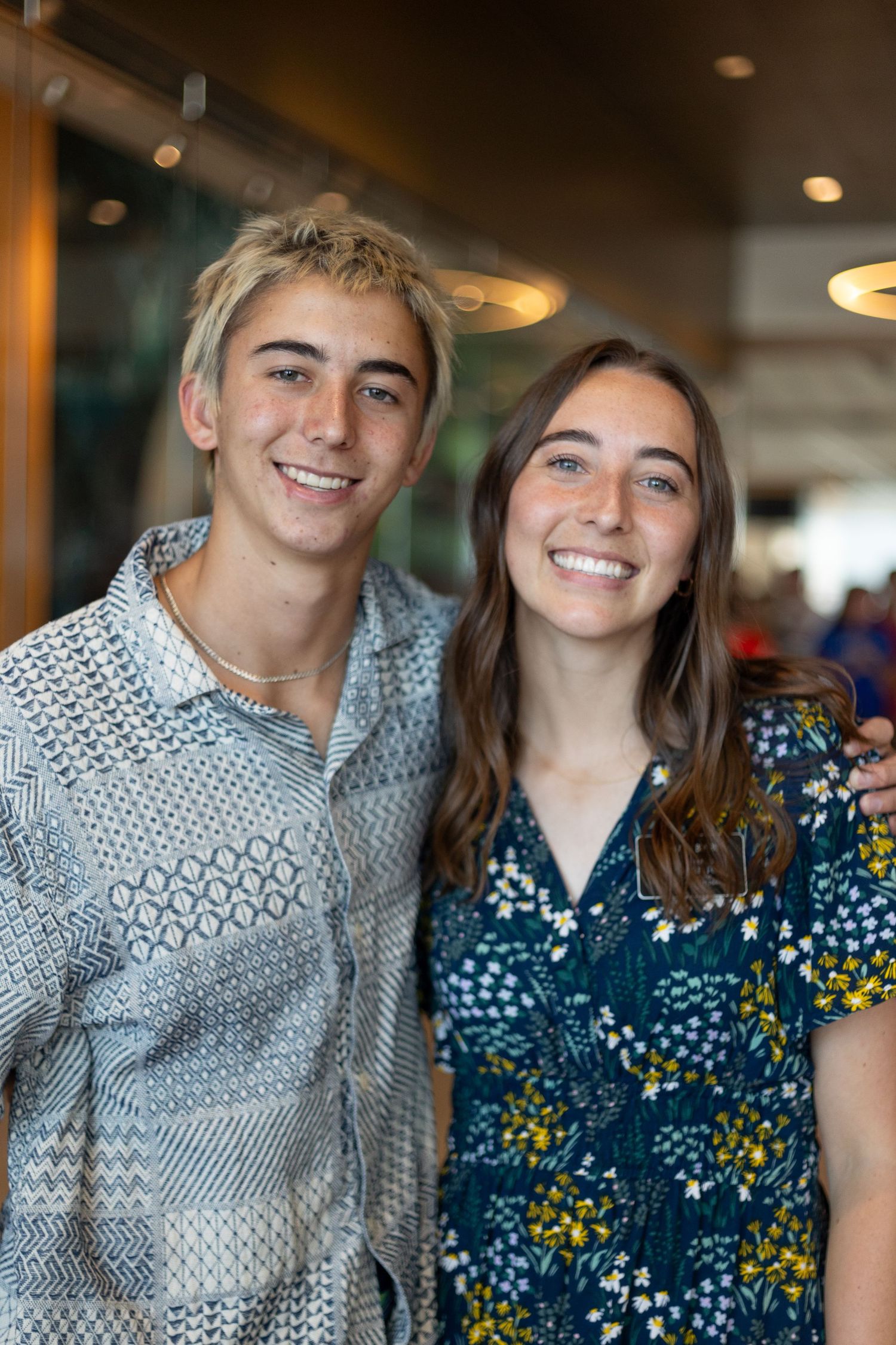 A smiling young man and woman pose together at a missionary homecoming celebration event.