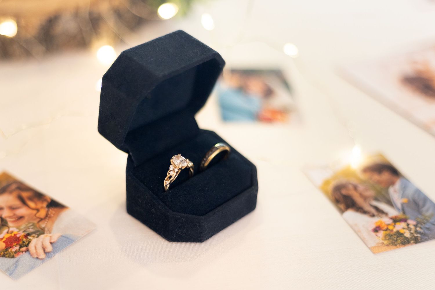 Gold diamond engagement ring and wedding band displayed in a black velvet ring box.