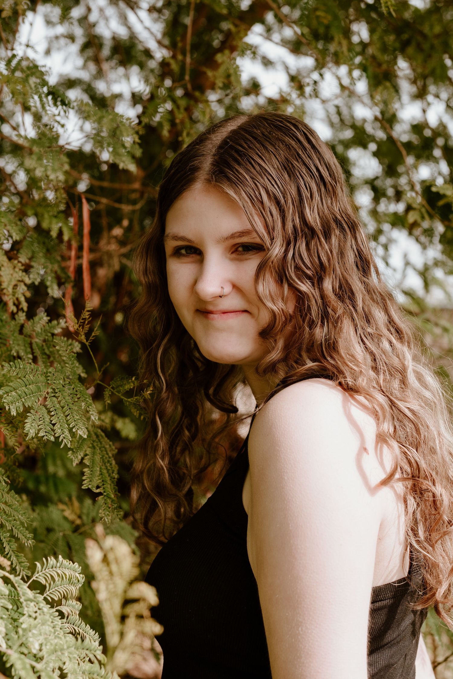 Artistic portrait against green foliage background in warm natural lighting.