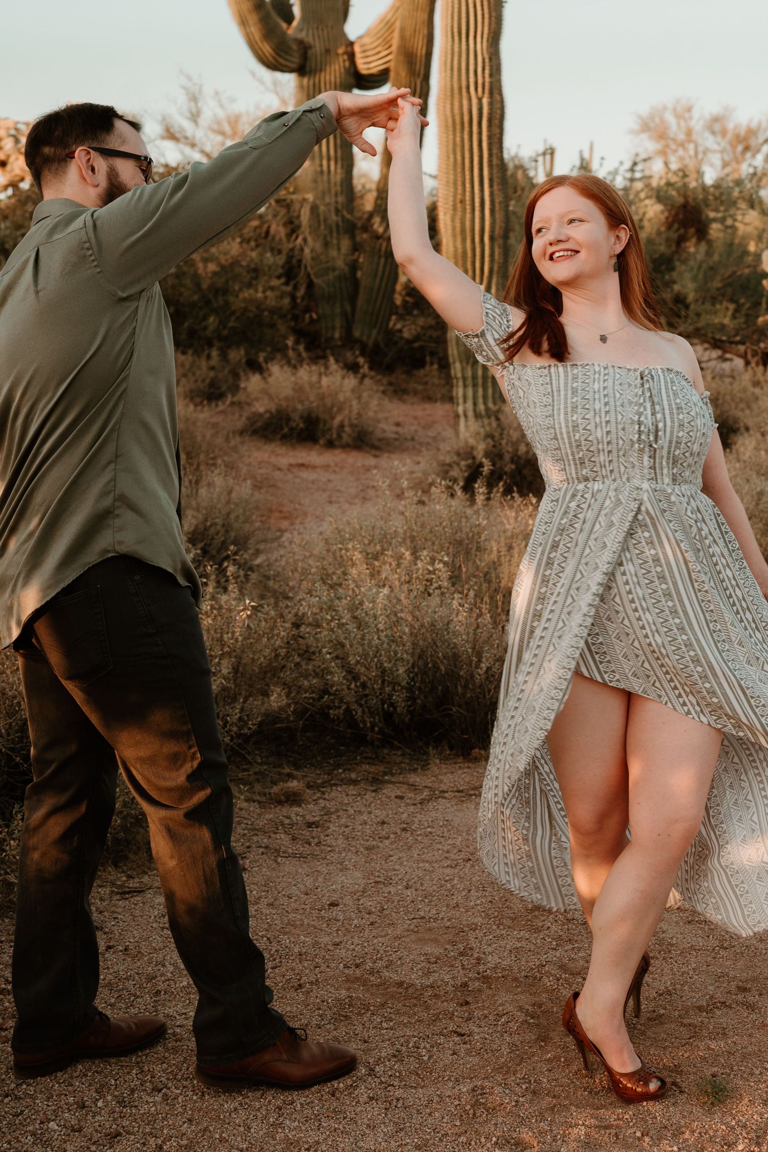 Playful desert photoshoot showing striped dress movement and dancing.