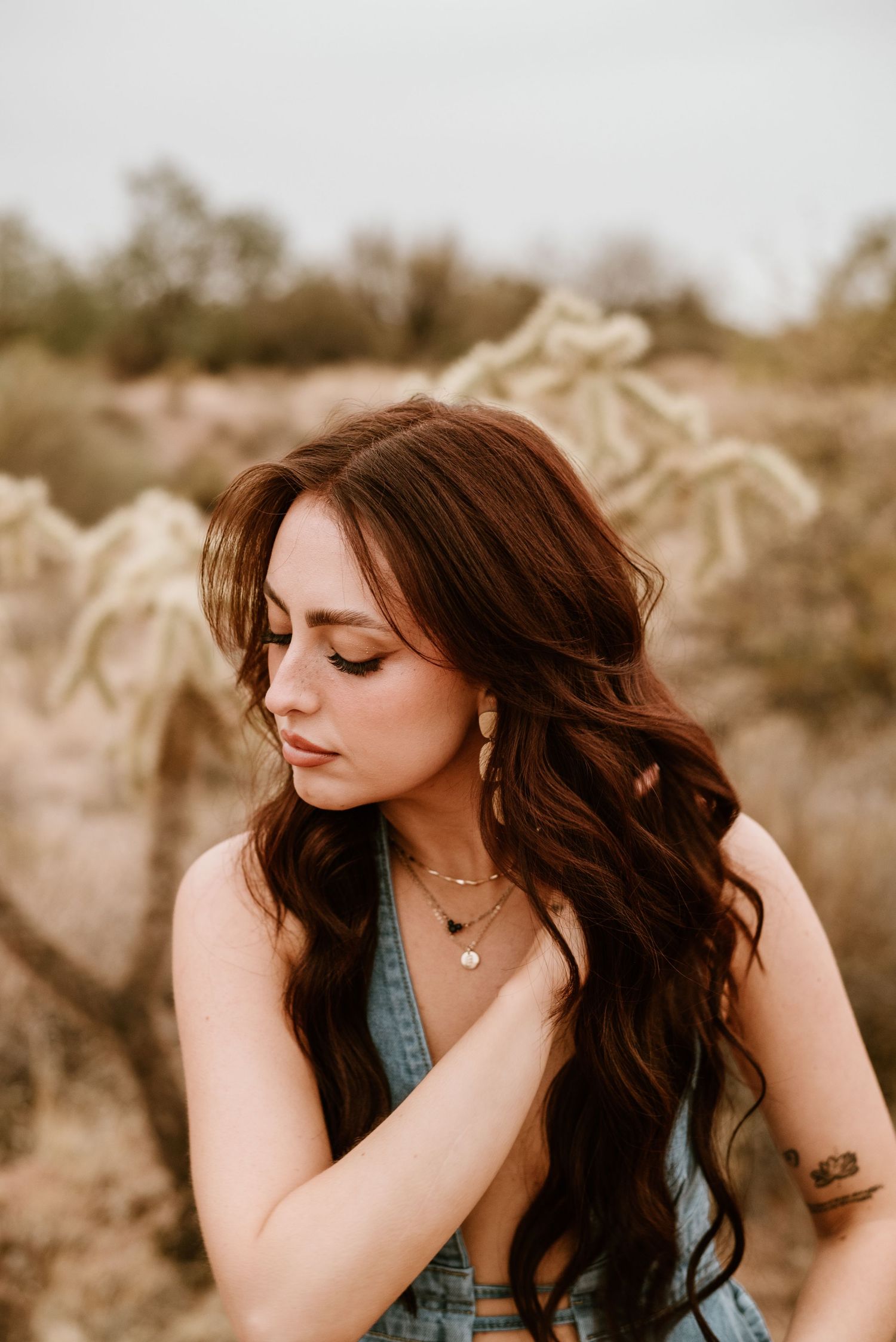 Portrait in desert setting with soft lighting and natural tones.