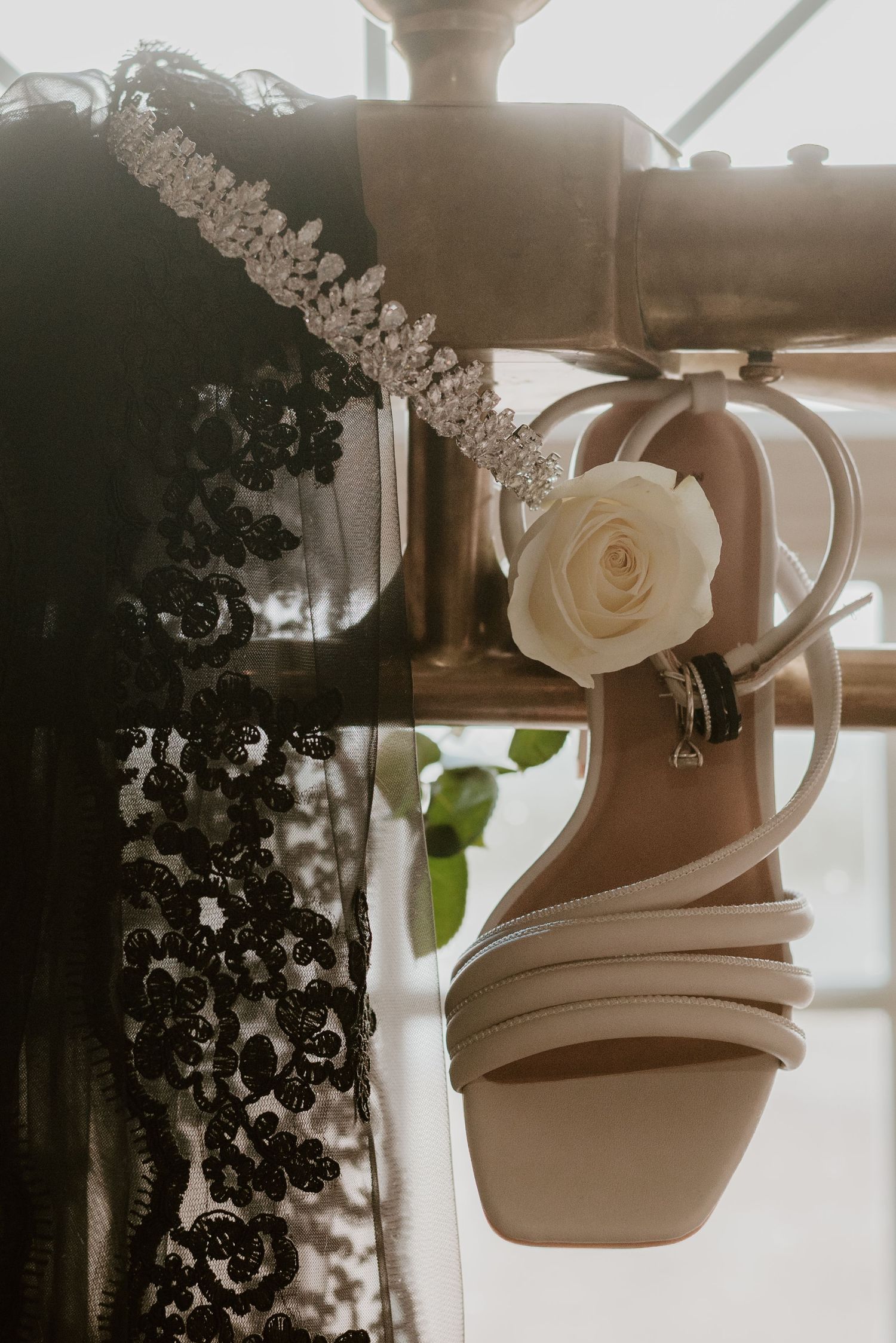 Wedding shoes and accessories artistically captured in soft window light.