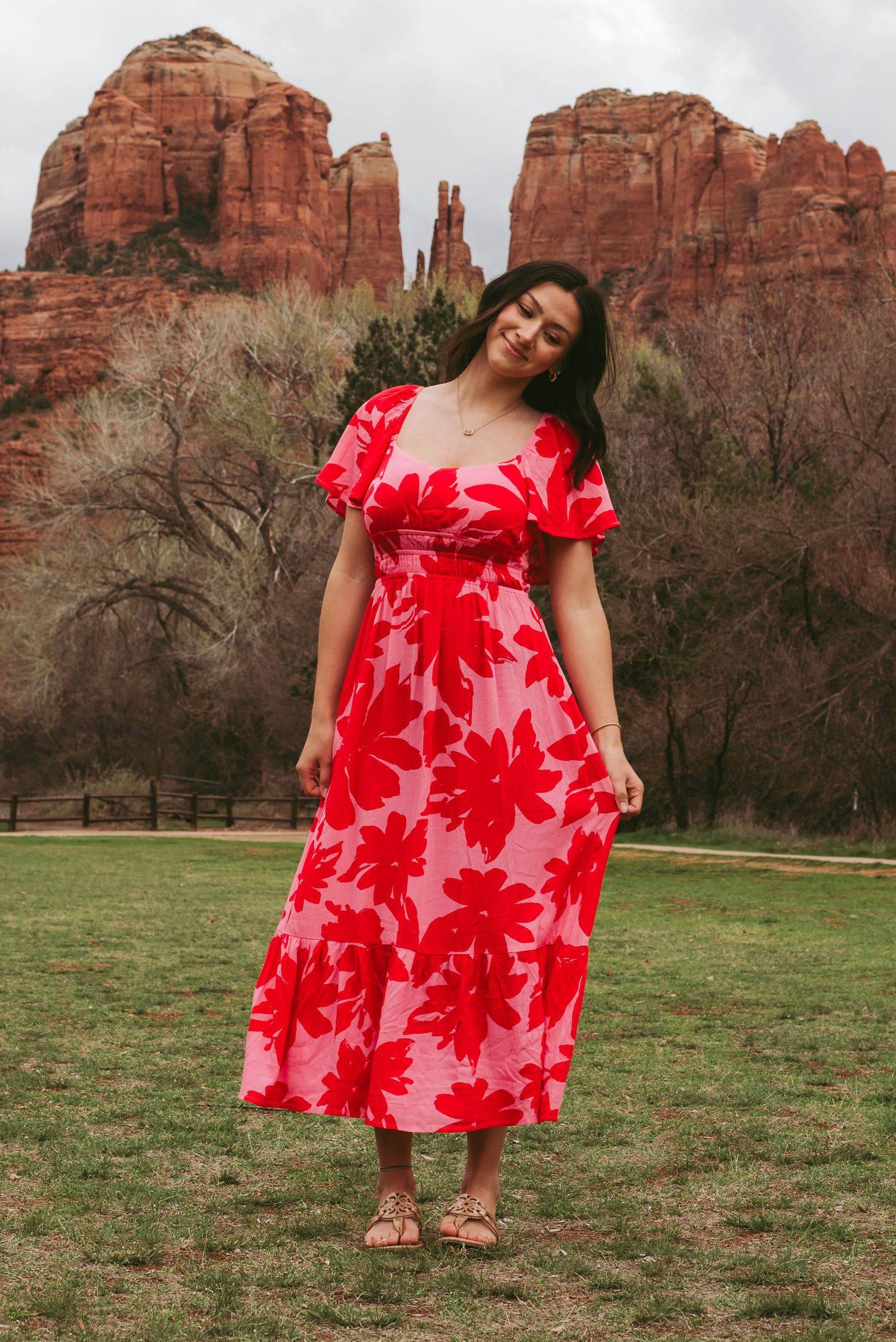 Full length shot of red floral maxi dress against Sedona rock formations.