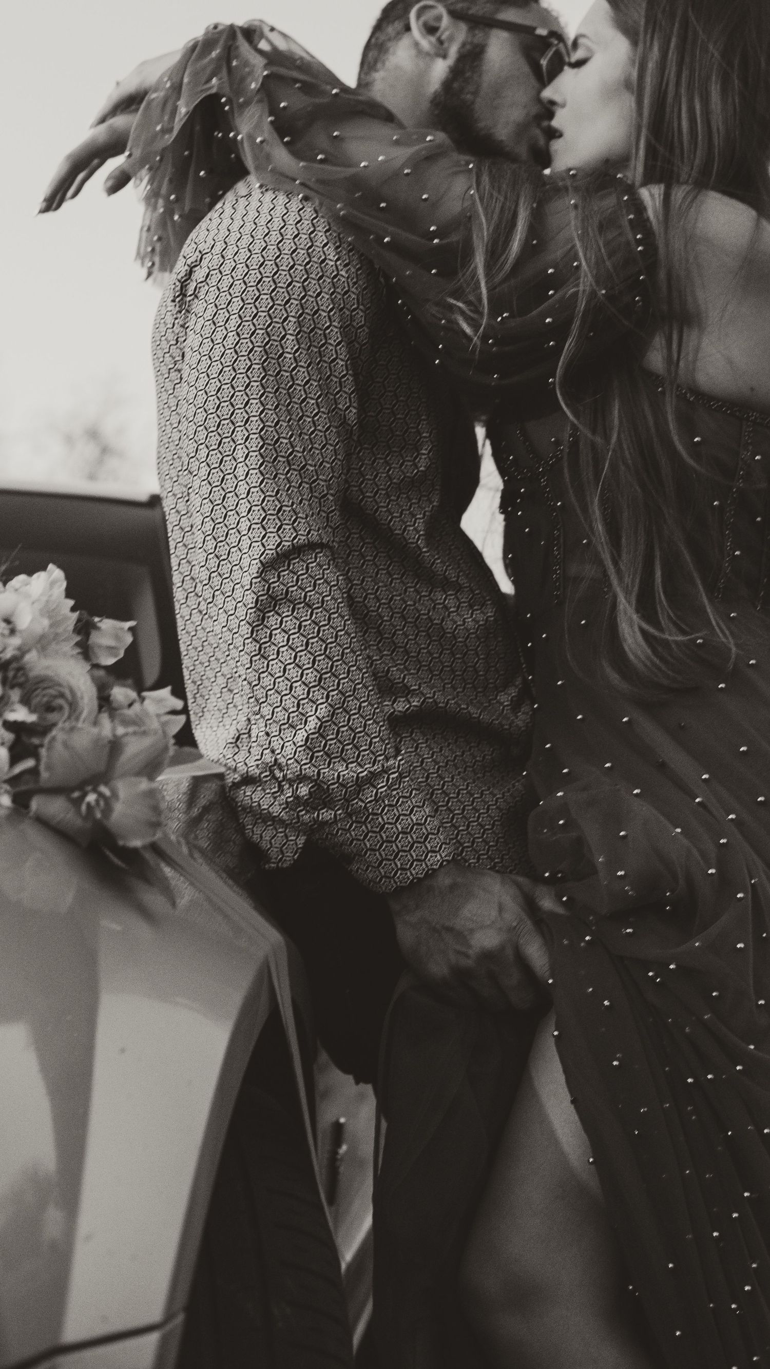 Black and white photo of couple with sparkly dress and knit sweater.