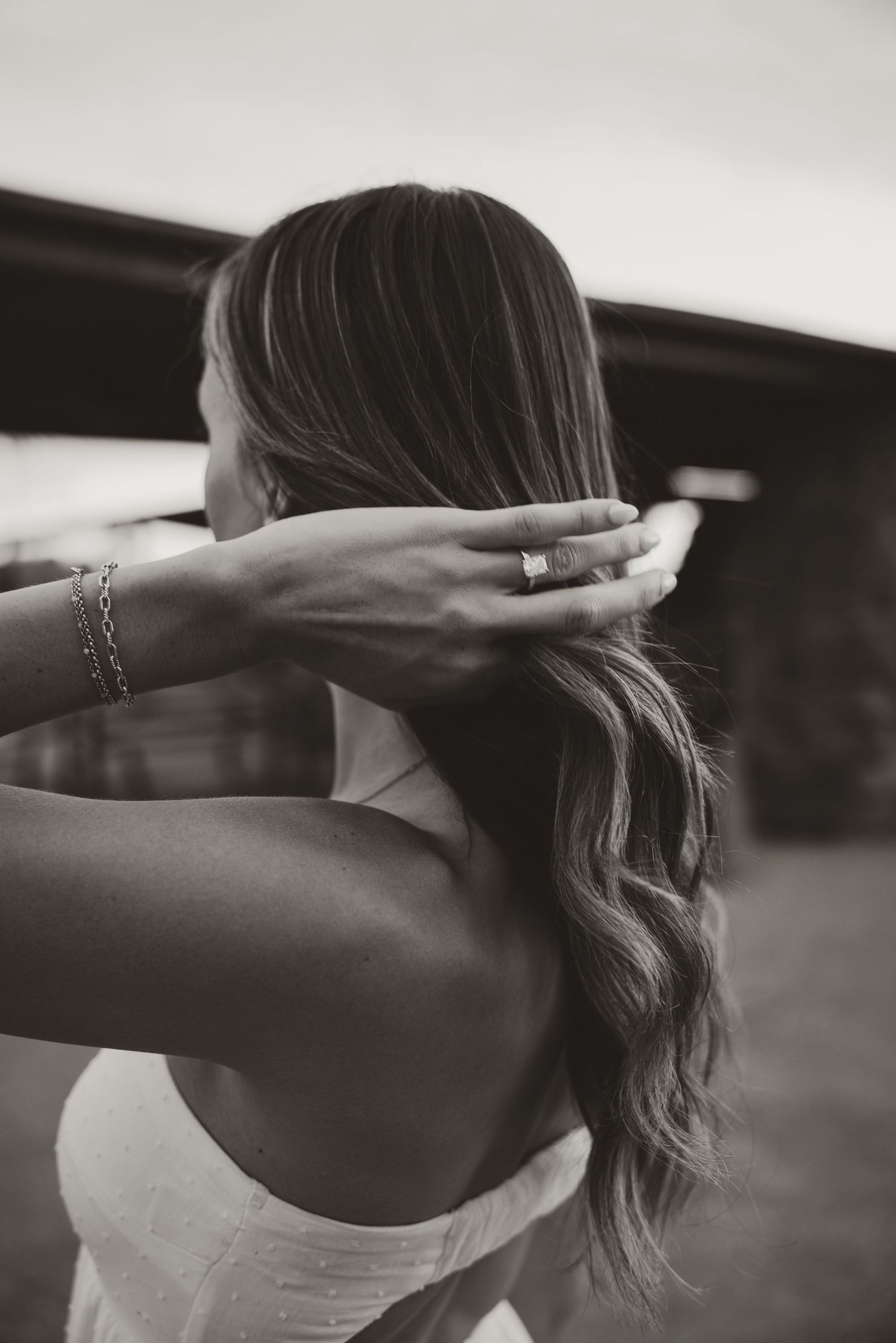 Black and white silhouette of person with flowing hair stretching arms upward.