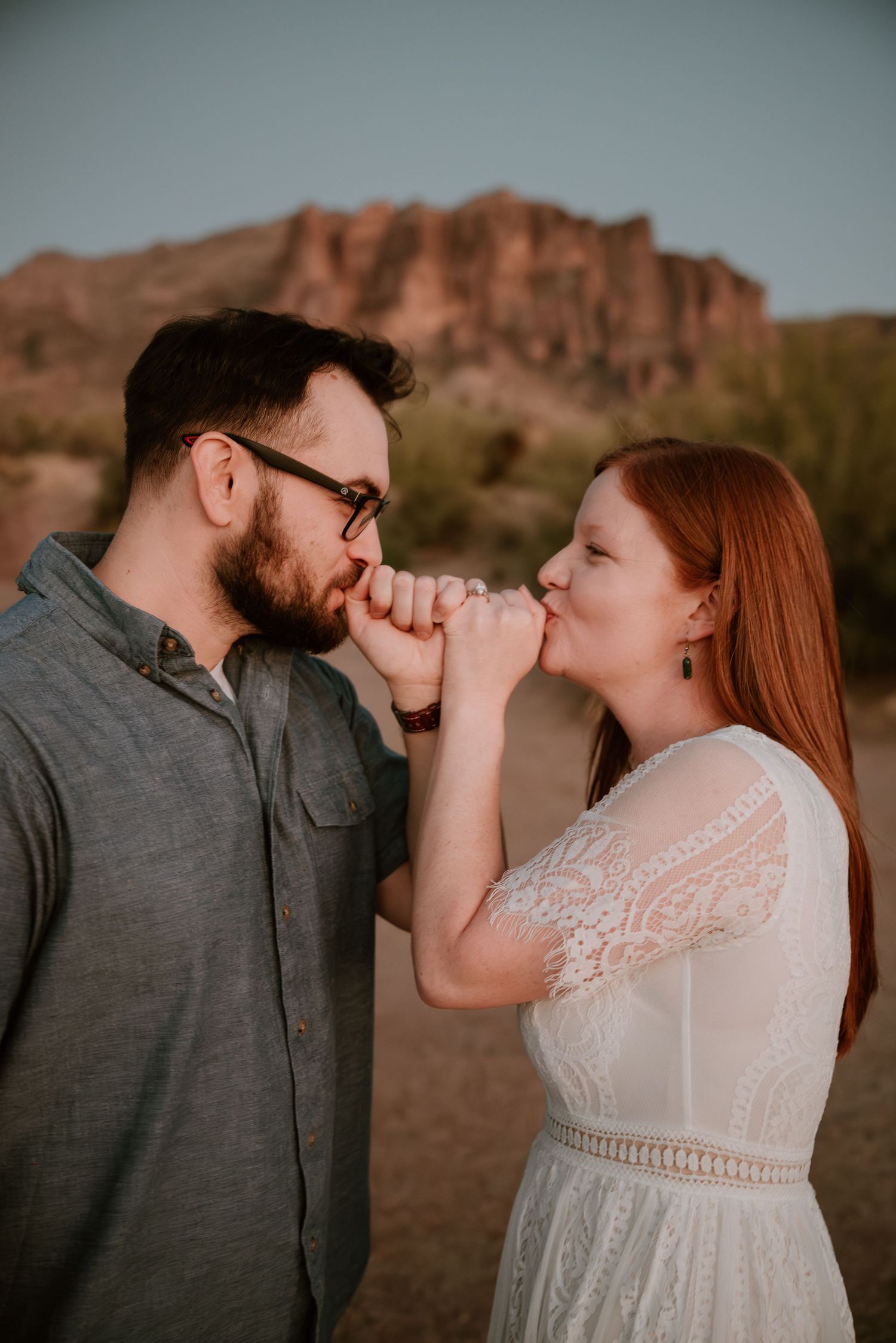 Tender moment captured between couple in desert landscape.