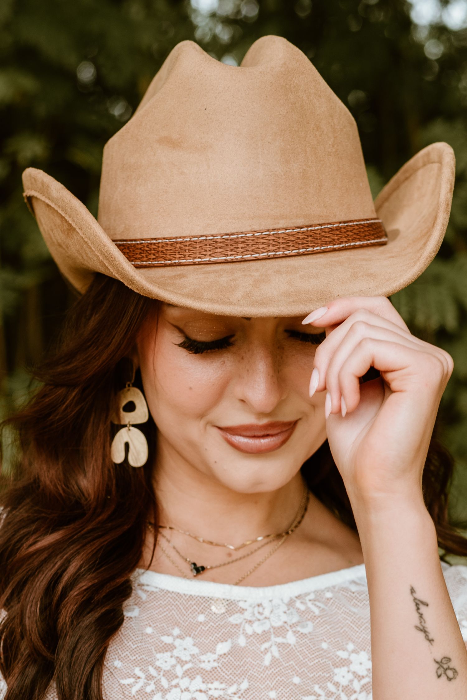 Brown cowboy hat tilted down in stylish western portrait.