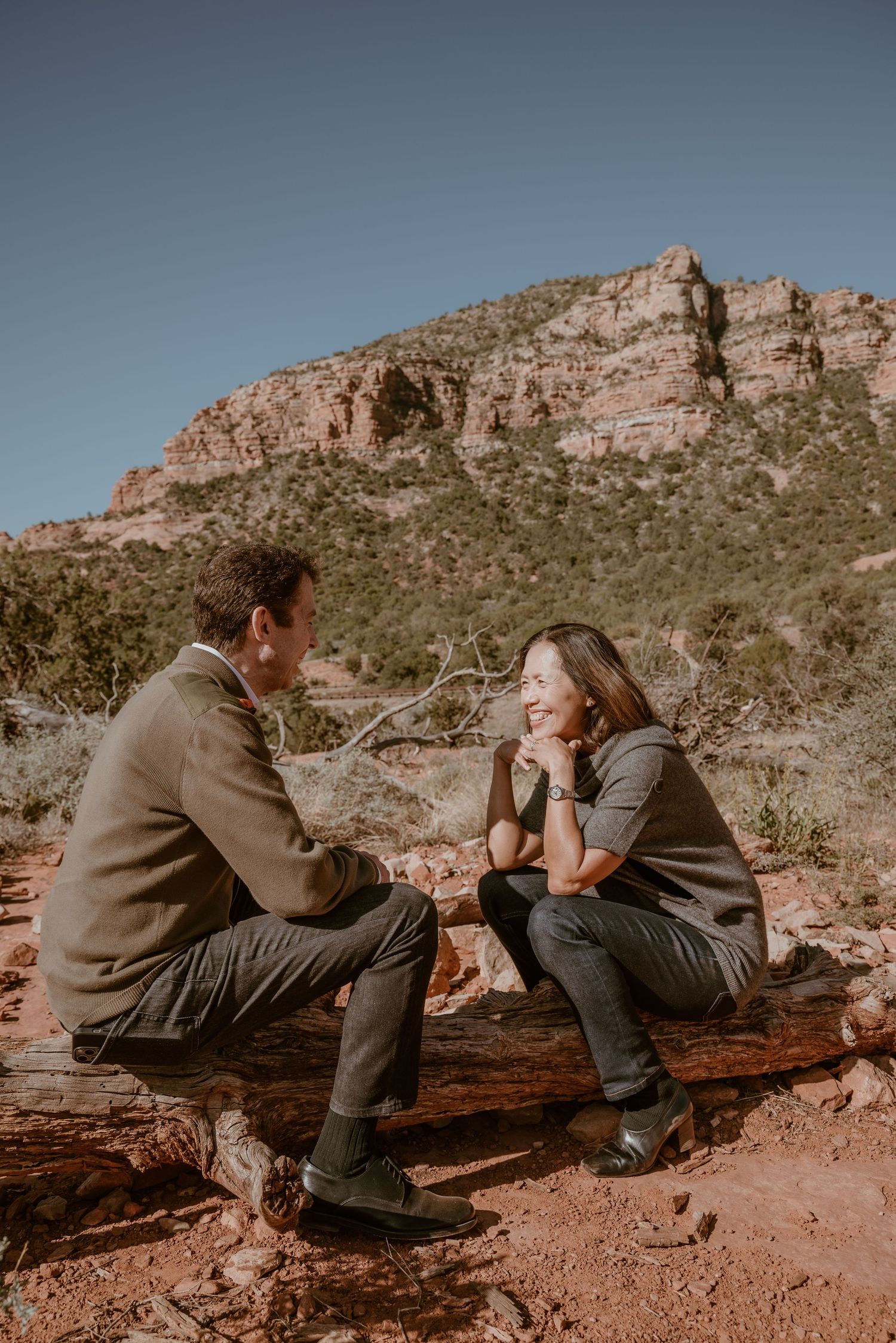 Couple sitting on desert rocks having a casual conversation.