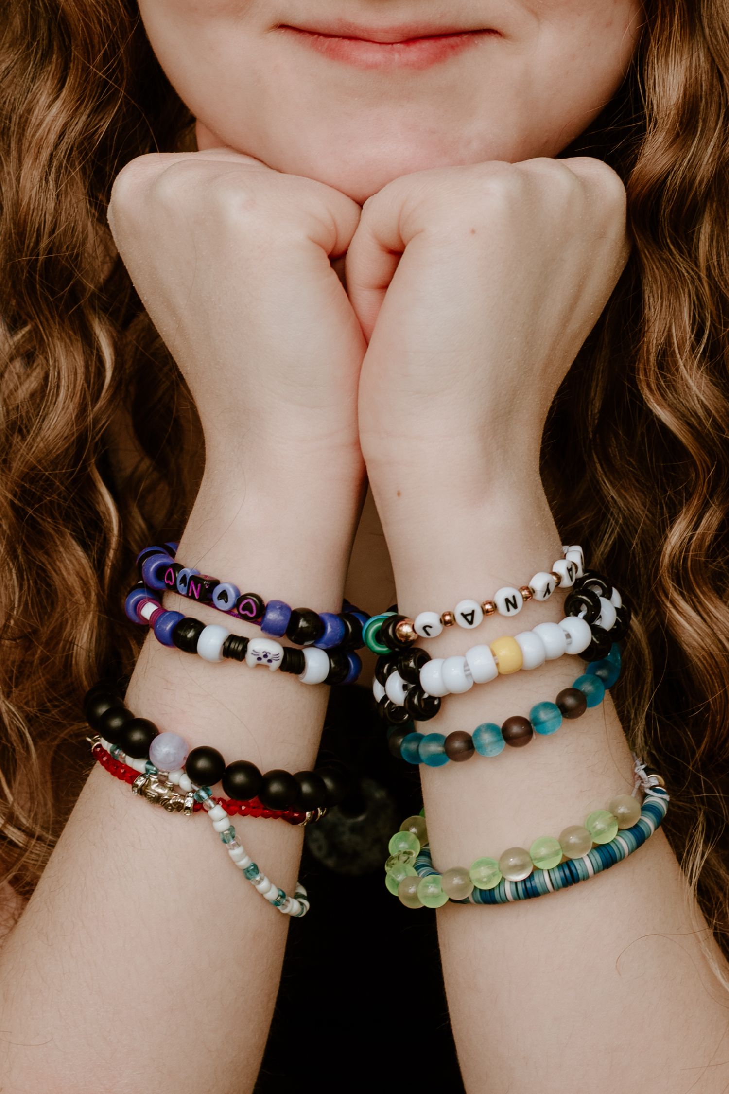 Colorful beaded bracelets displayed against a dark background showing various designs and colors.