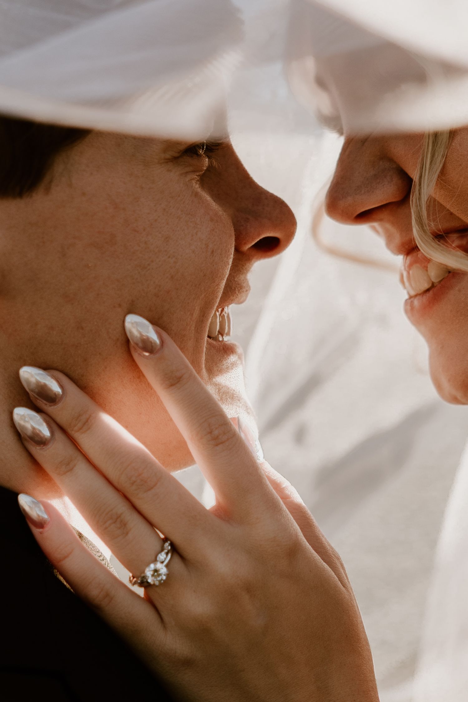 Artistic close-up of hands showing engagement ring in natural light.