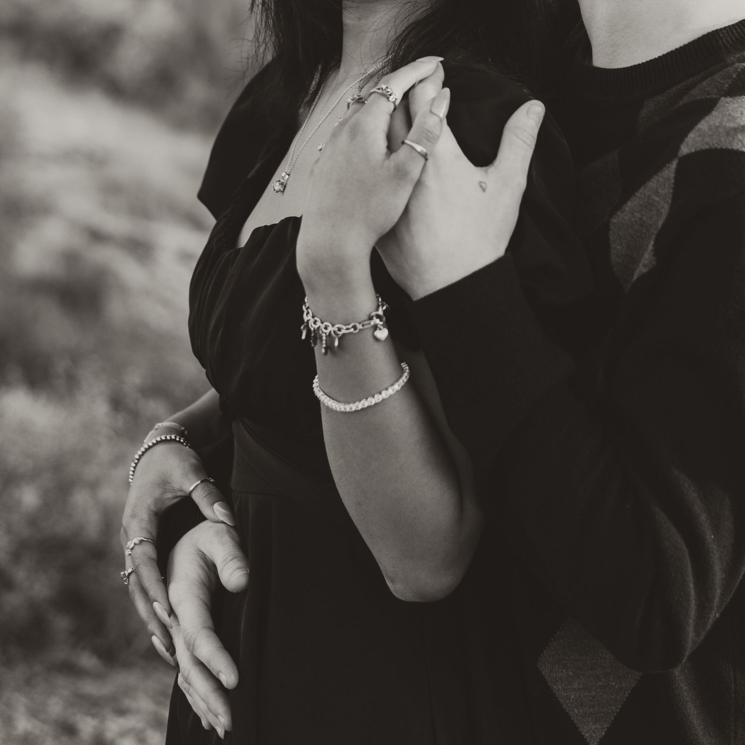 Black and white photo showing elegant jewelry details and formal attire.