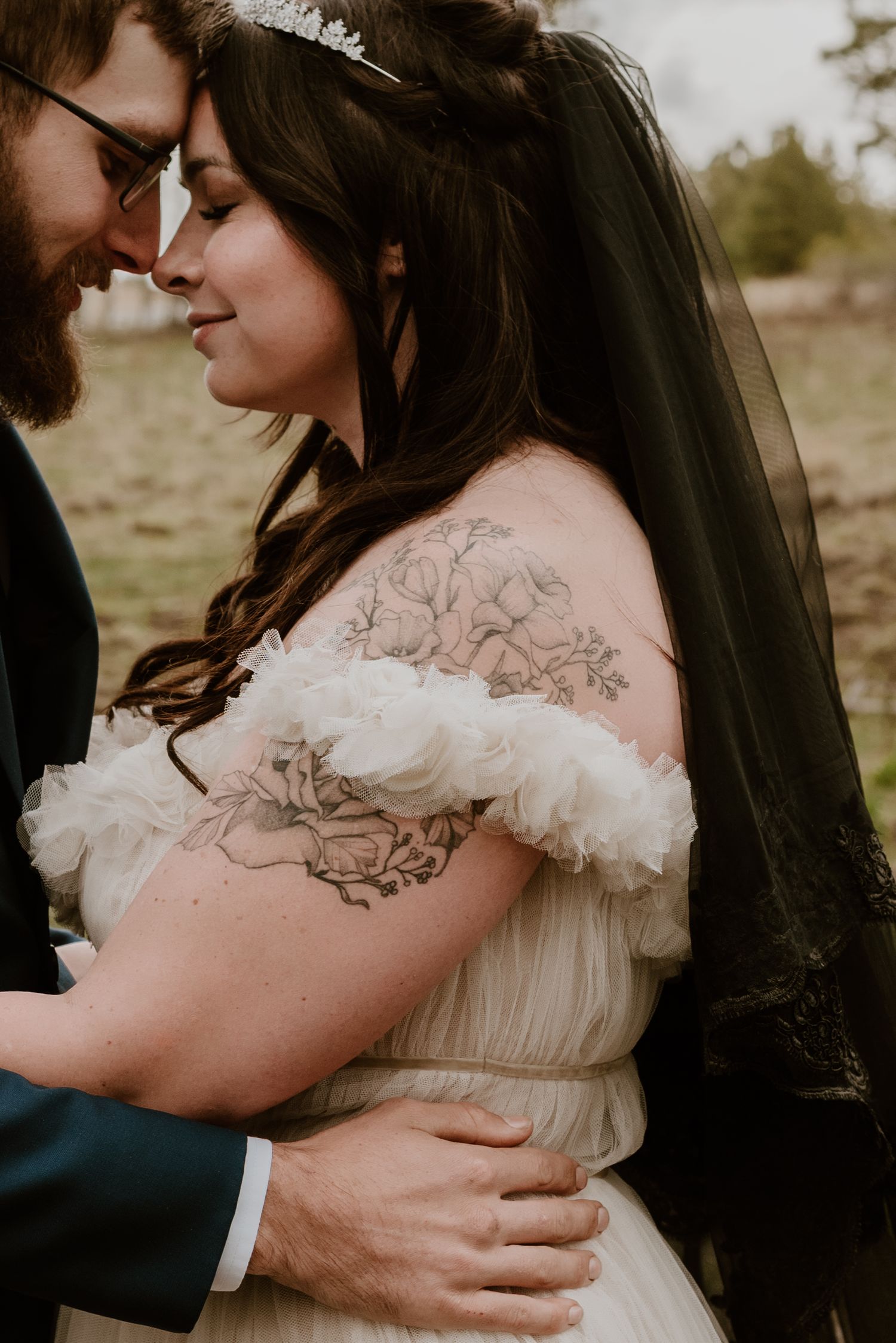An intimate wedding portrait showcasing delicate dress details and tender moments in natural light.