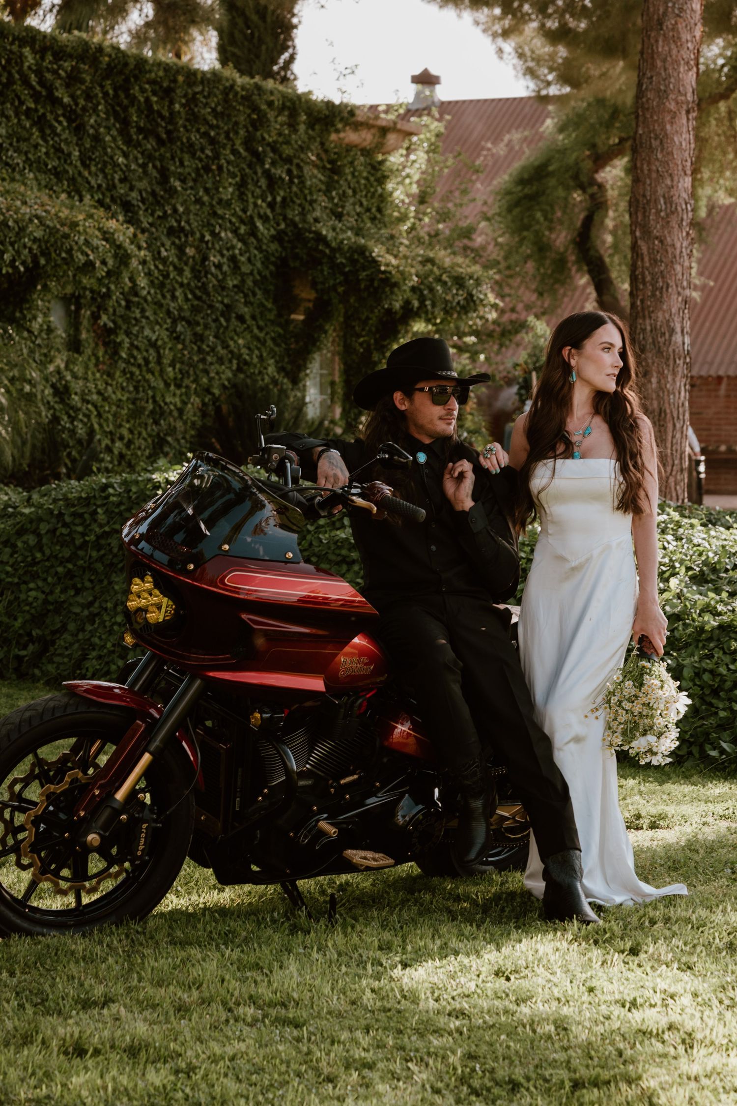 Outdoor wedding scene with vintage motorcycles and floral decorations on grass.