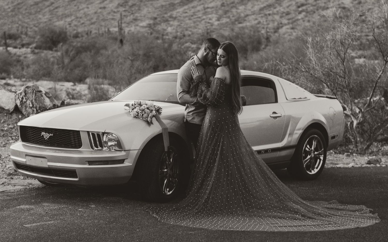 Classic car with wedding dress train in black and white photography.