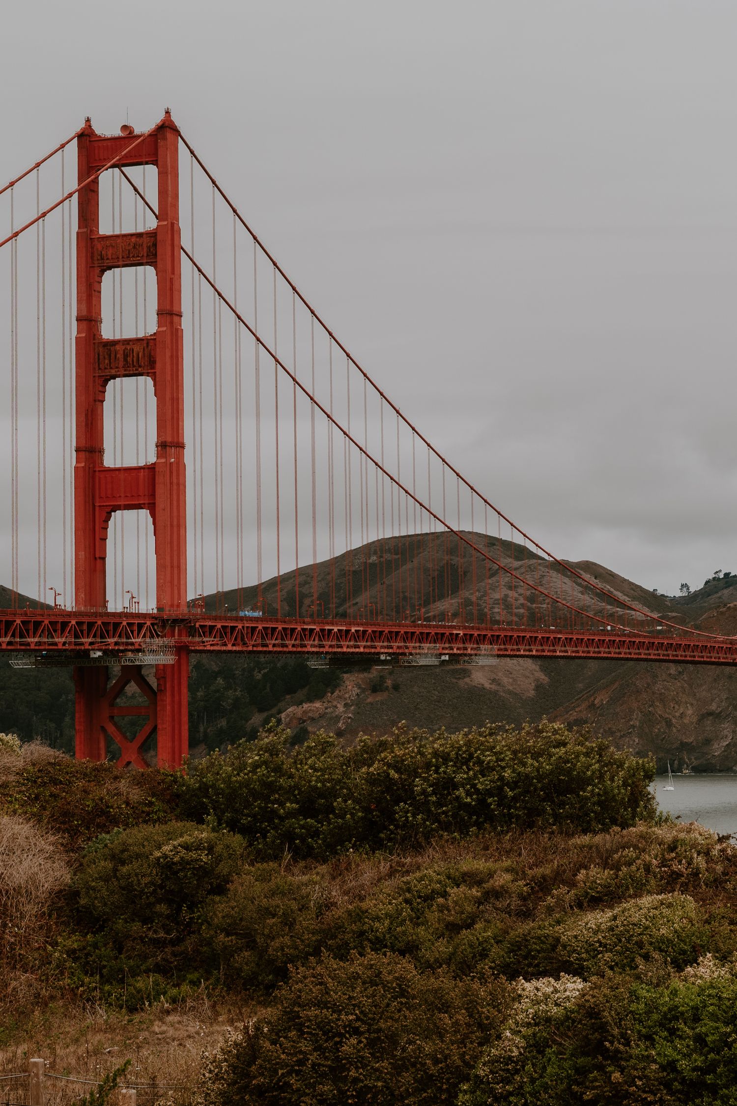 The iconic Golden Gate Bridge spans across the bay under overcast skies in San Francisco.