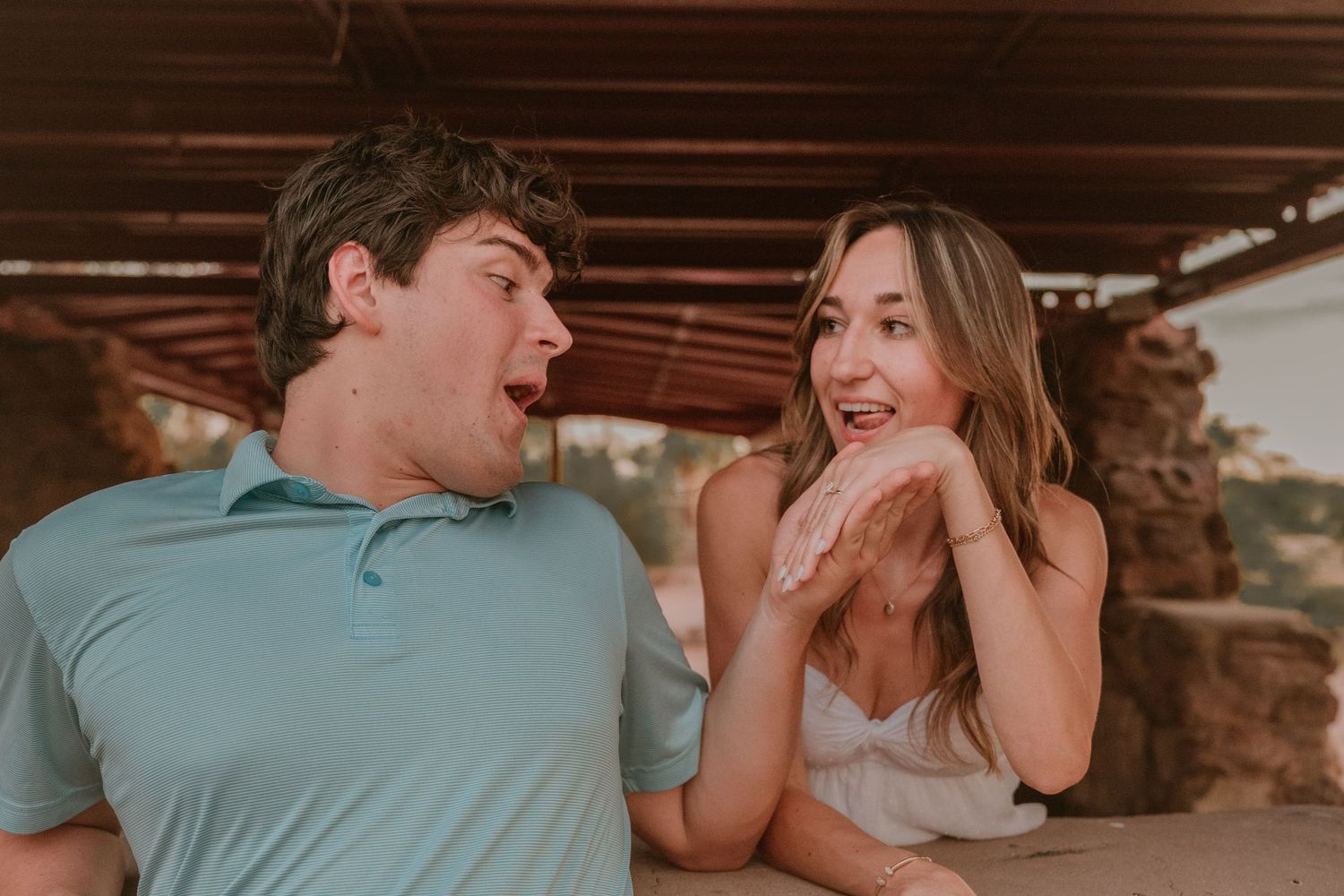 Couple sharing joyful laughs in casual attire indoors.