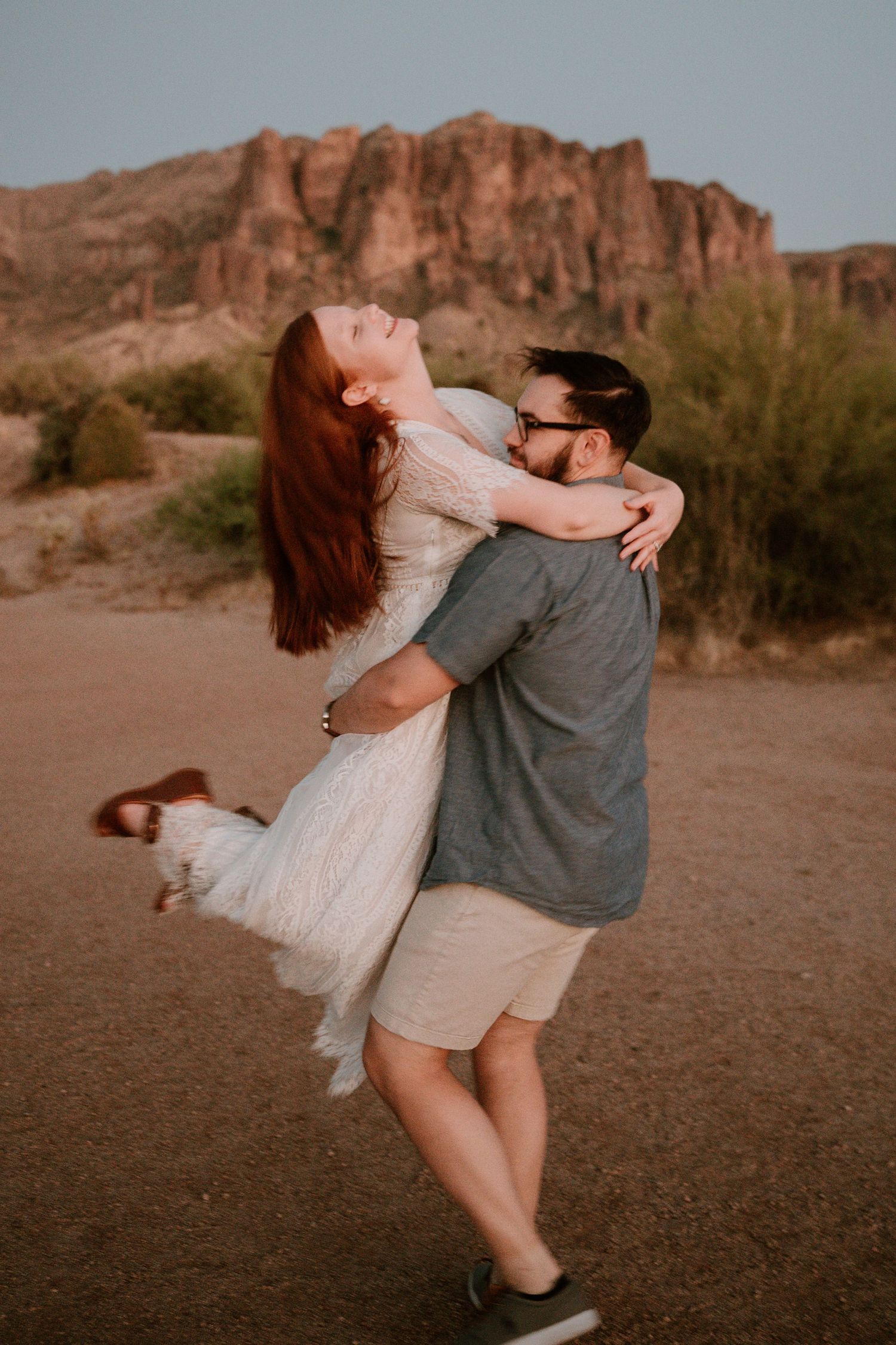 Romantic dancing scene in desert setting with mountains in background.