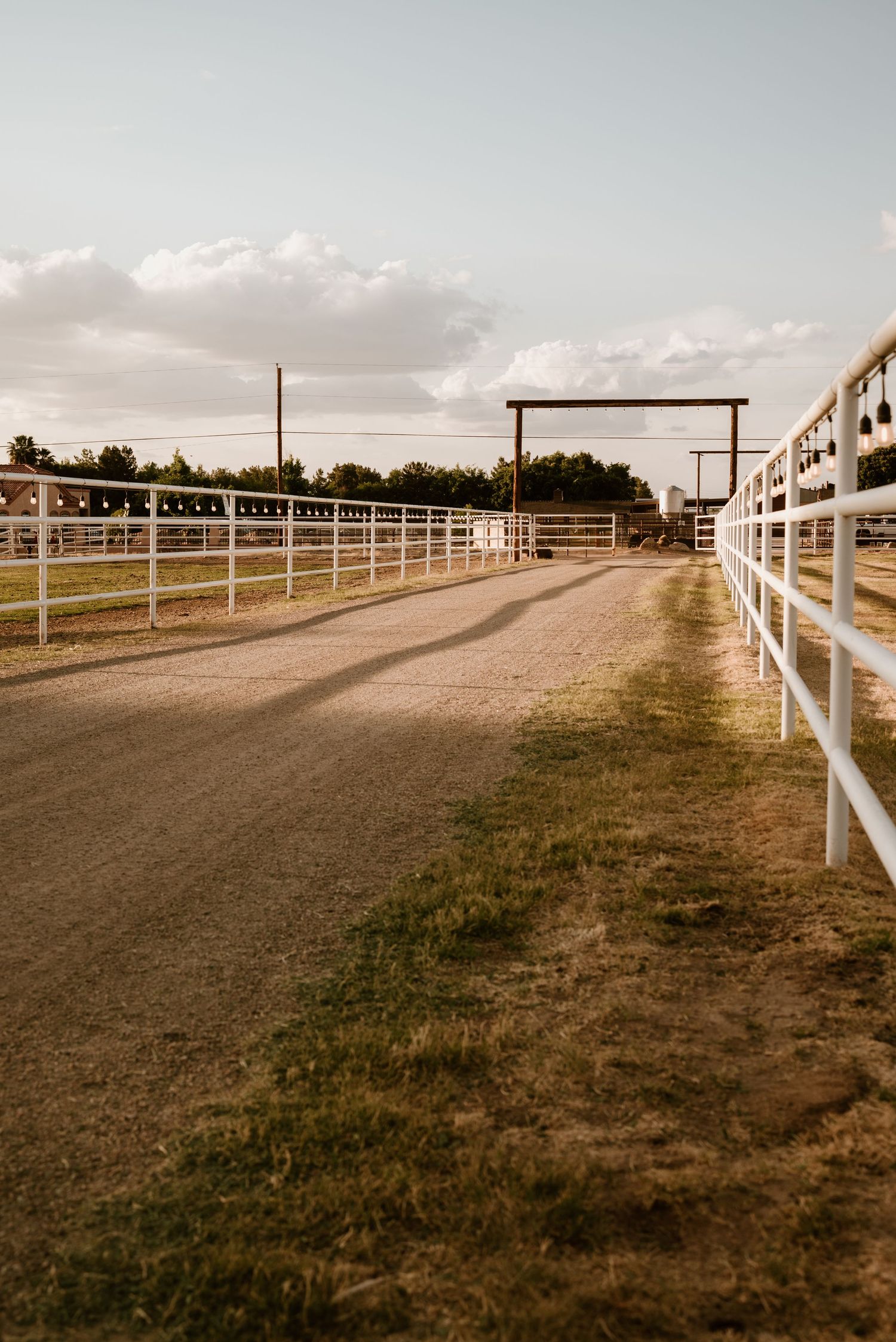 Long gravel path bordered by white fencing stretches into the distance.