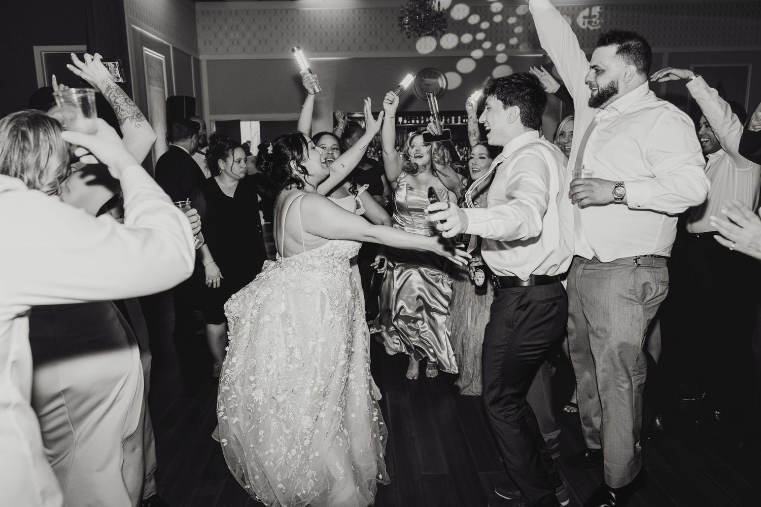 Black and white photo of wedding guests and bride and groom dancing during the wedding reception in Boston Massachusetts