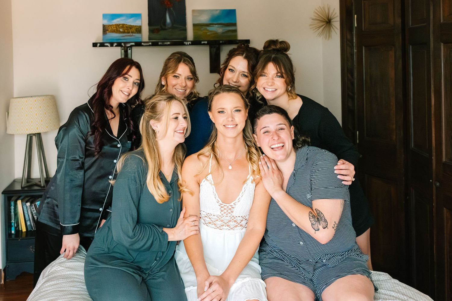A group of people sharing joyful moments and laughter while sitting together on a couch at a social gathering.