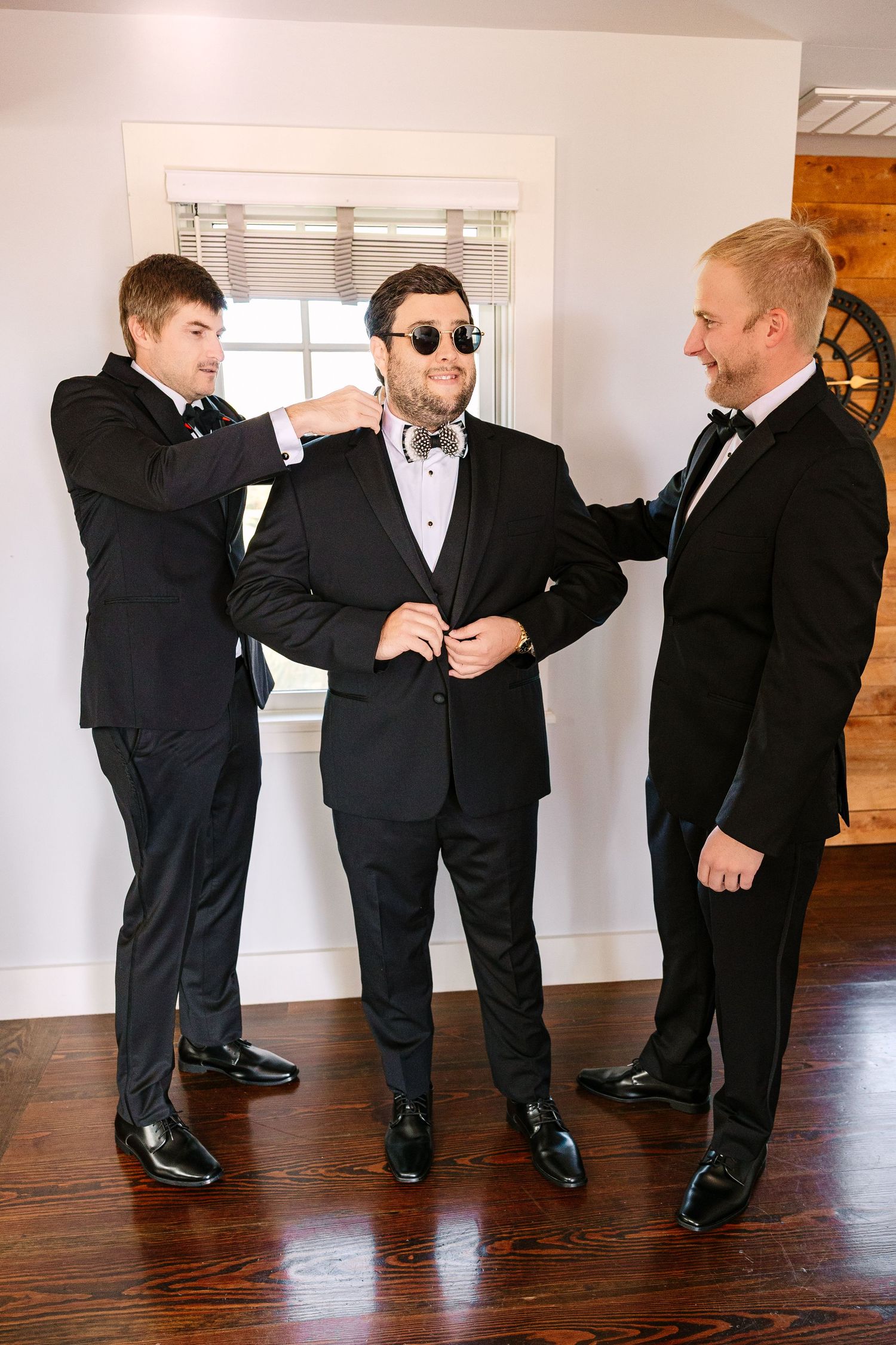 A sequence of four photos showing groomsmen performing a fun dance move on a hardwood floor at a wedding.