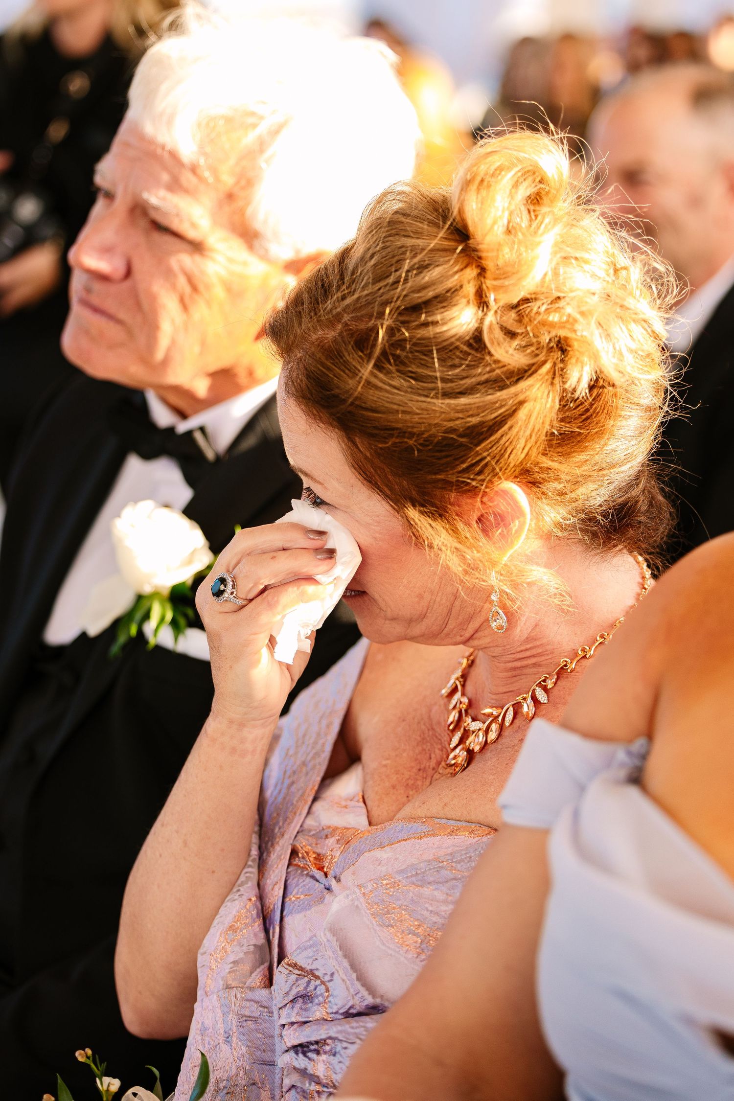 An emotional mother of the groom wipes tears during an intimate wedding ceremony at The Regatta Place in Newport Rhode Island