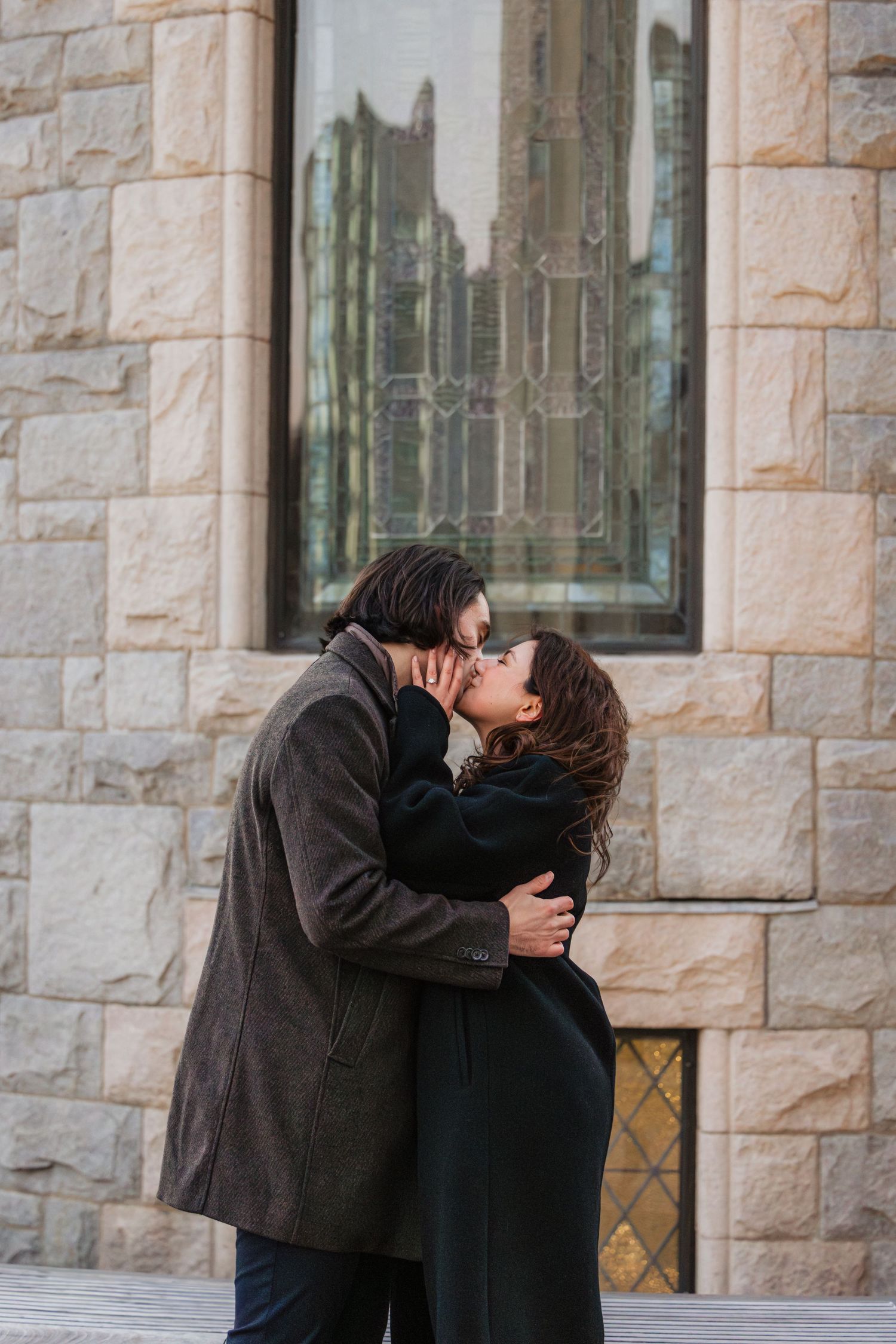 A romantic winter surprise proposal engagement photo of couple kissing in Boston Massachusetts