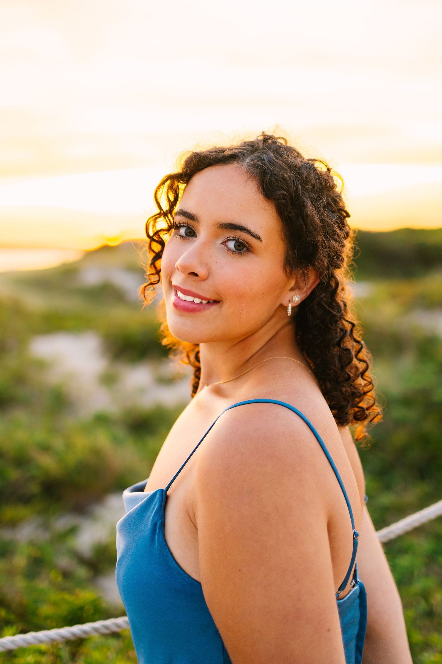 A high school senior close up senior portrait by the sand dunes at sunset golden hour at Horseneck Beach in Westport, Massachusetts