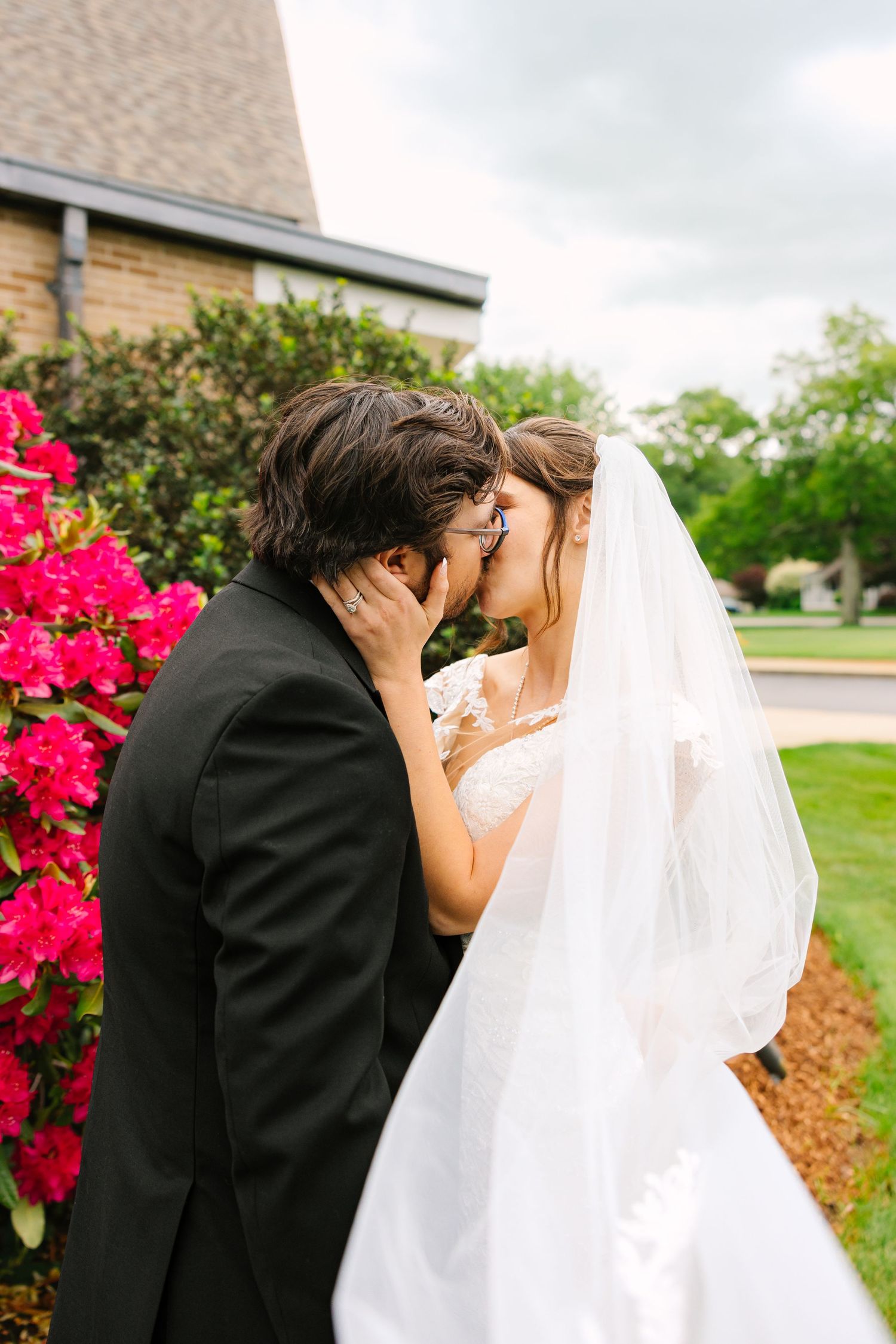 Newlyweds sharing a kiss taking portraits together in the springtime at Cape Club of Sharon in Sharon, Massachusetts
