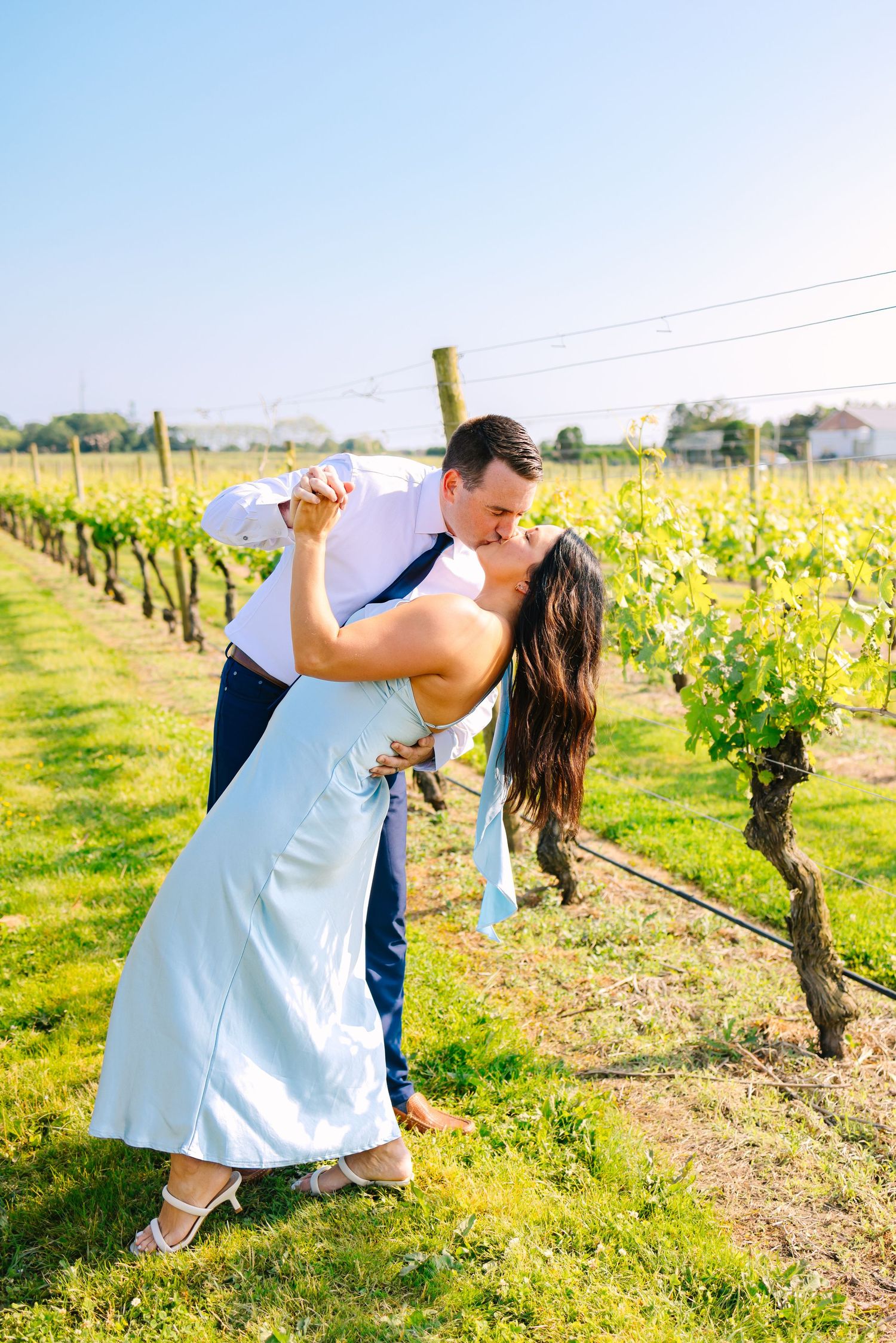 A couple romantically kiss and dance in the vineyard at Newport Vineyards in Newport Rhode Island for engagement photos