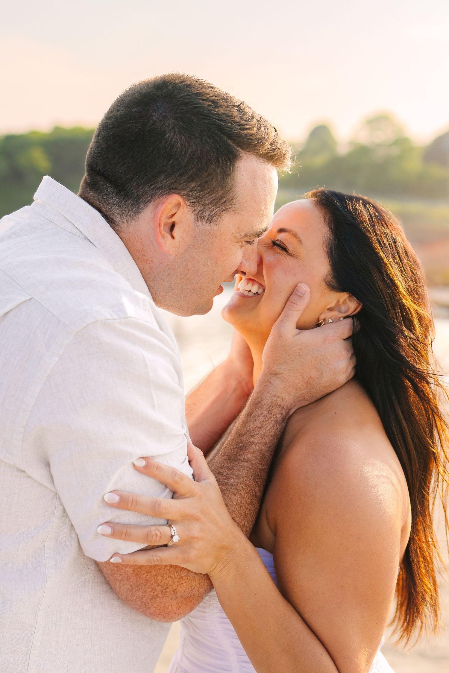 Romantic couple intimately embracing during engagement photos at sunset golden hour at Second Beach in Newport, Rhode Island