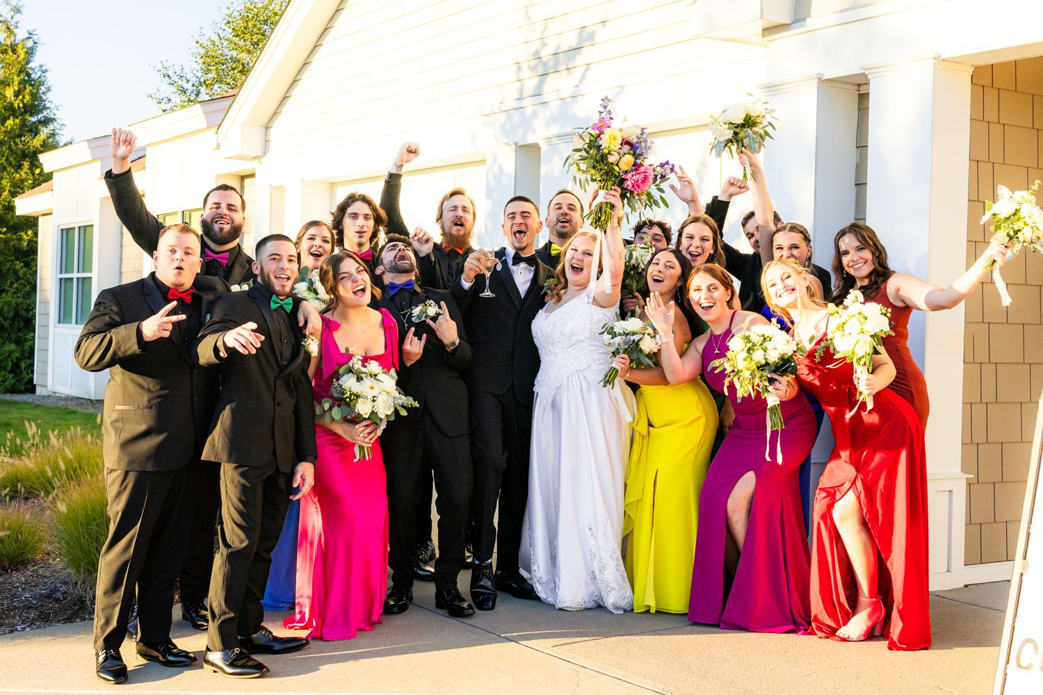 A colorful wedding party celebrate during portraits after ceremony at wedding venue in South Coast Massachusetts