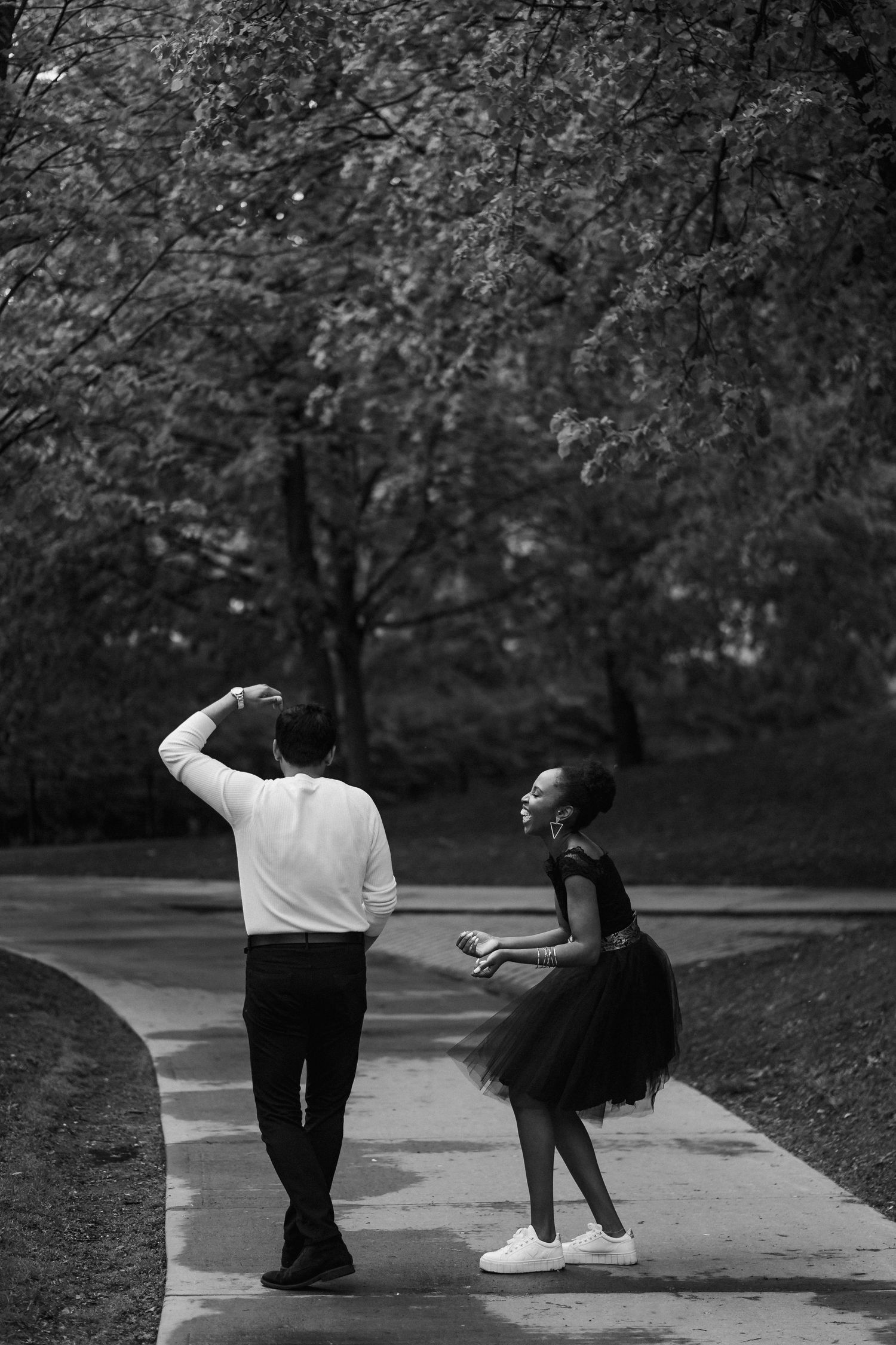 A playful black and white photo sequence showing a couple dancing in a park setting.